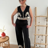 Wunderschönes Set aus einer locker fallenden Hose und einer kurzen Weste. In schwarz mit beiger Blumen Stickerei im unteren Bereich der Weste und der Hose sorgt dieses Set garantiert für besondere Eleganz.
