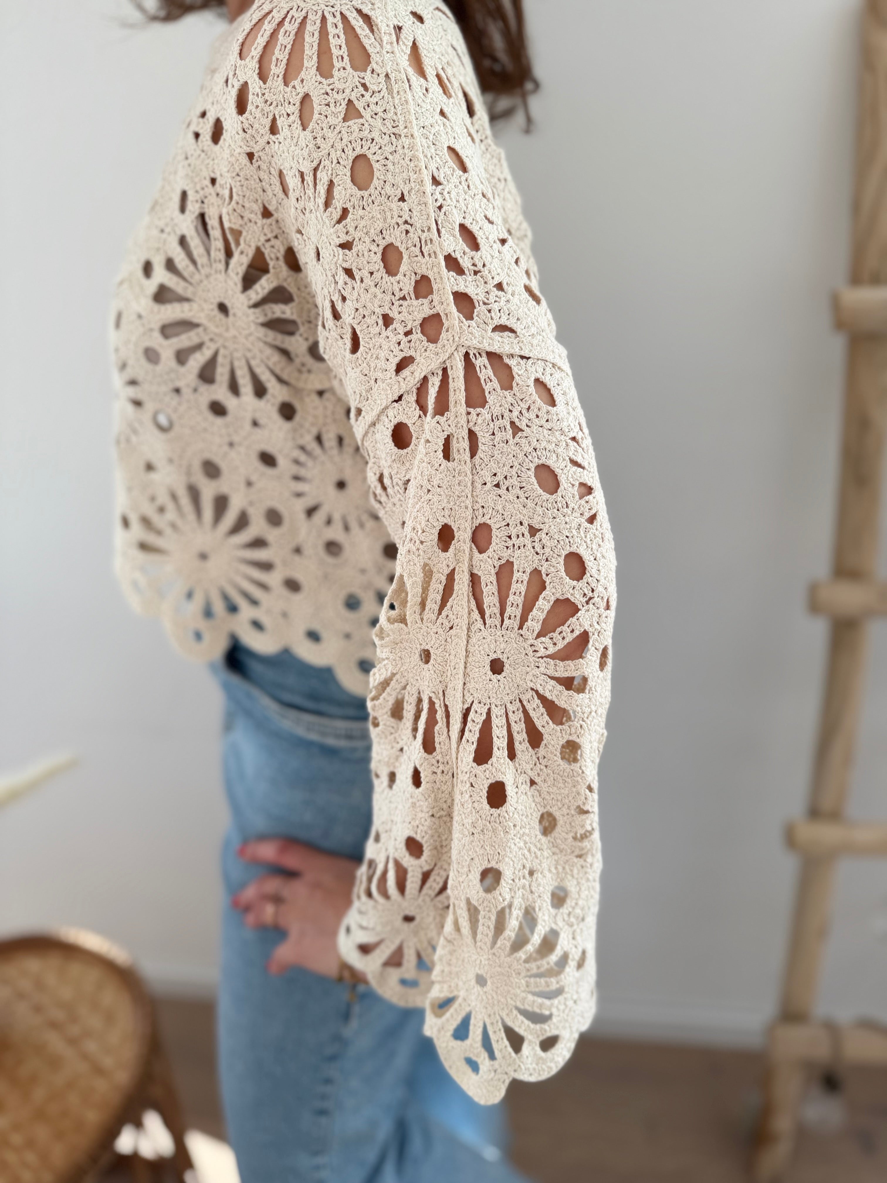 Kurzpullover mit verspieltem Blumenmuster in Häkeloptik. Die langen Schlagärmel runden den Boho Look perfekt ab. Der Pulli ist beige.