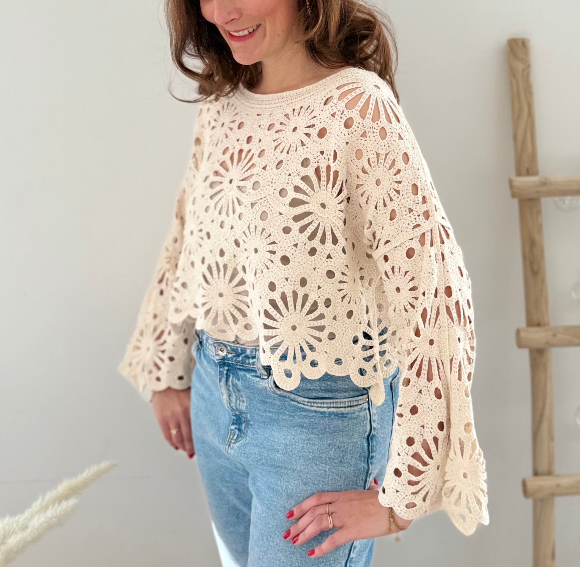 Kurzpullover mit verspieltem Blumenmuster in Häkeloptik. Die langen Schlagärmel runden den Boho Look perfekt ab. Der Pulli ist beige.