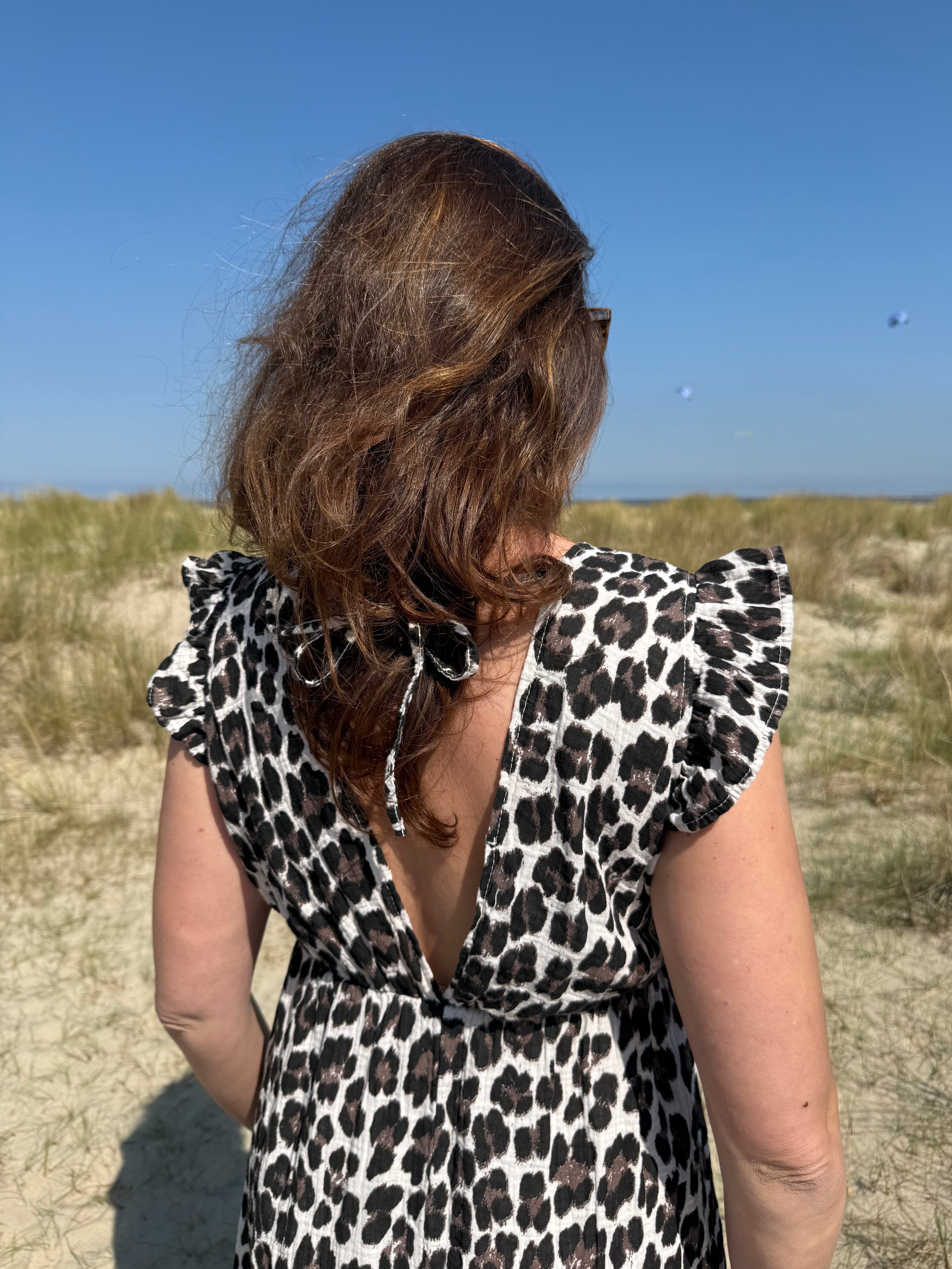 Langes Musselinkleid mit wunderschönem lockeren Schnitt und kurzen Flügelärmeln. Das Kleid hat einen V-Ausschnitt. Das Kleid ist im Leomuster in braun, schwarz & beige gehalten.