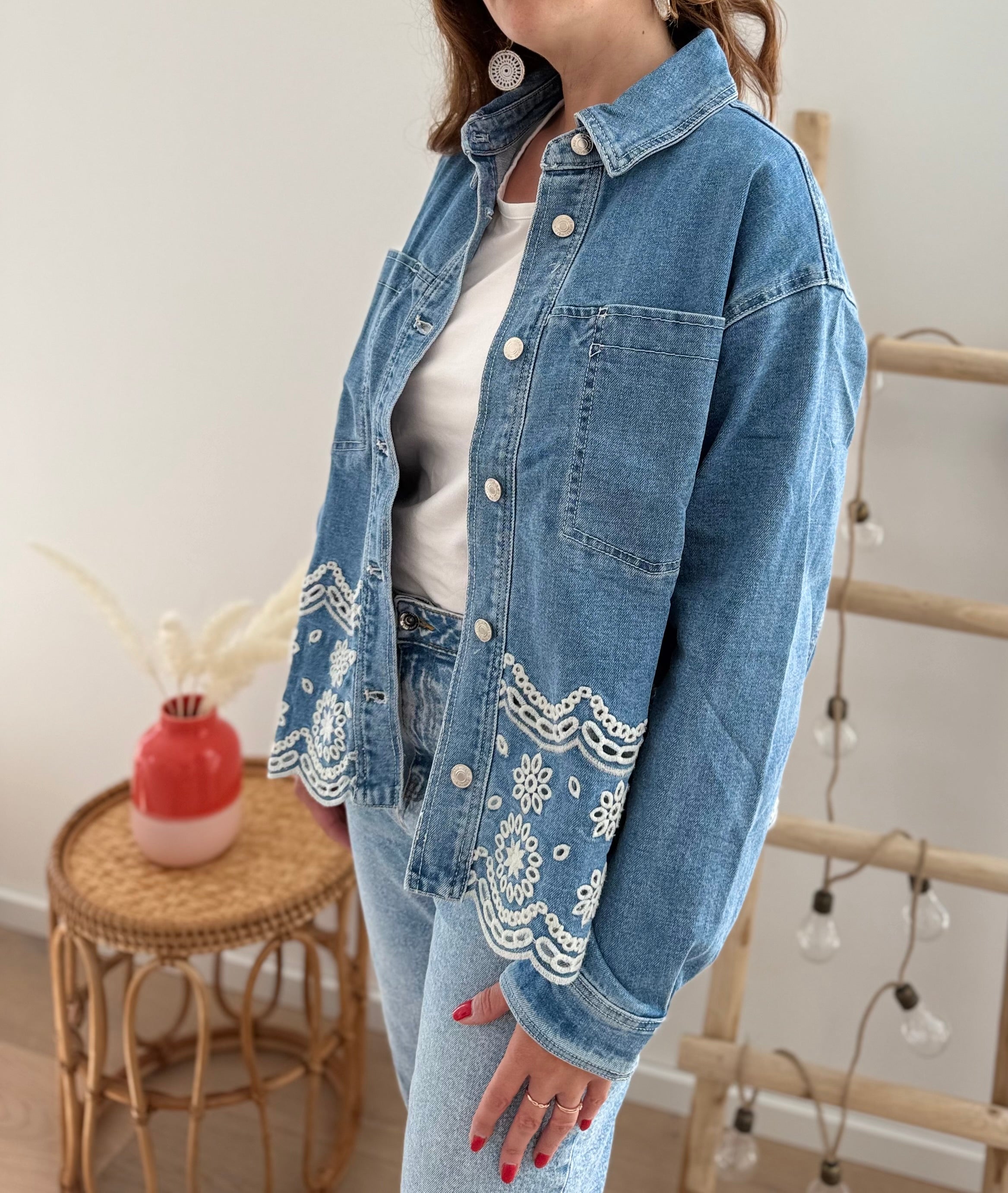 Verspielte blaue Jeansjacke im Oversize Look. Die wunderschöne weiße Lochstickerei mit Blumenmuster im unteren Bereich macht diese Jeansjacke zu einem ausgefallenen Lieblingsteil.