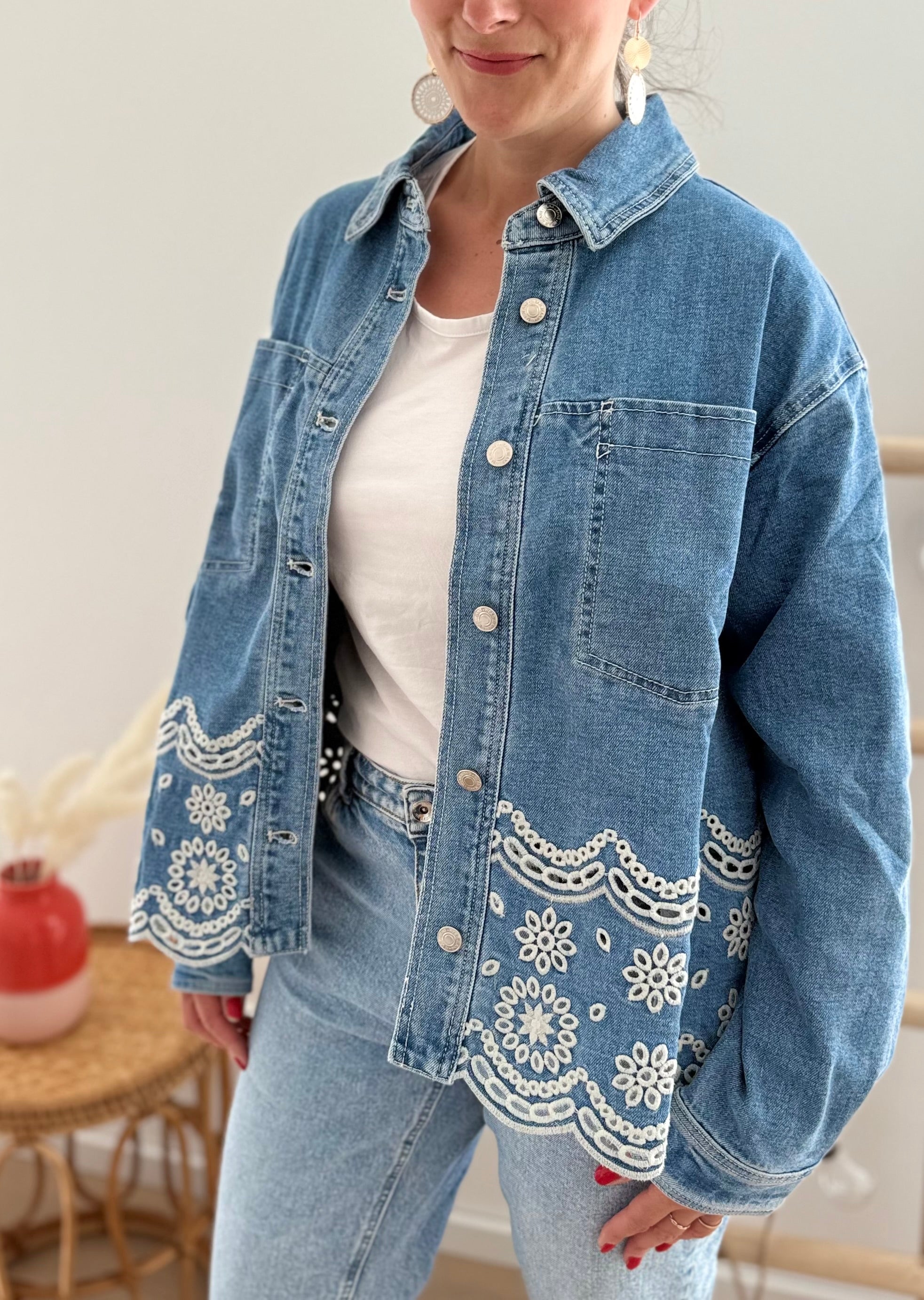 Verspielte blaue Jeansjacke im Oversize Look. Die wunderschöne weiße Lochstickerei mit Blumenmuster im unteren Bereich macht diese Jeansjacke zu einem ausgefallenen Lieblingsteil.