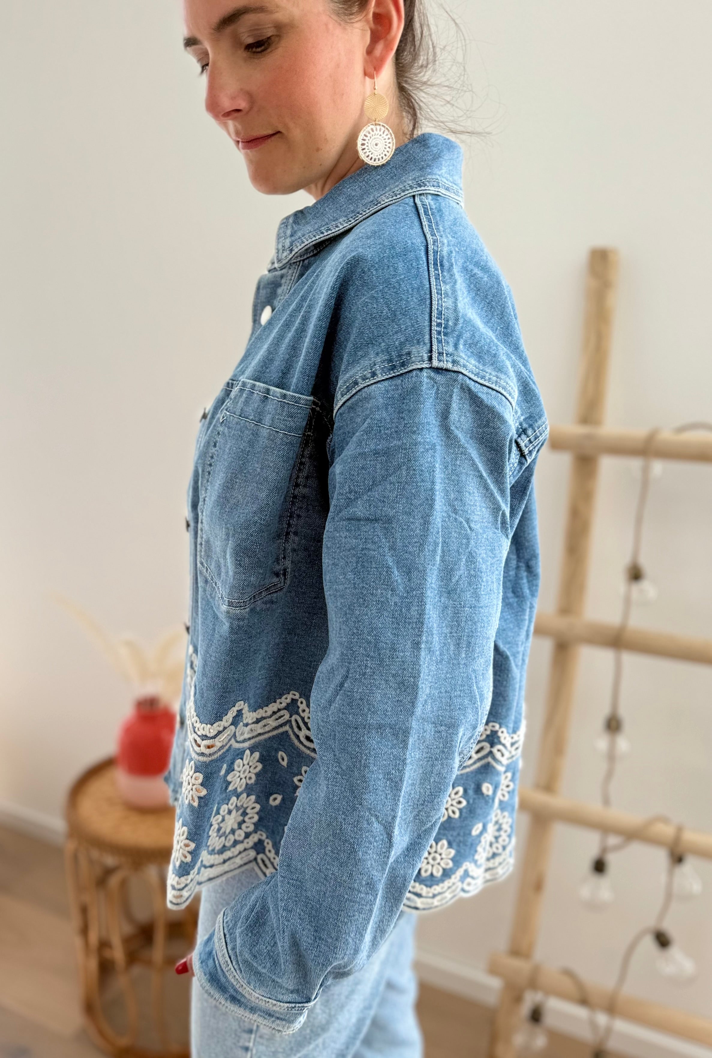 Verspielte blaue Jeansjacke im Oversize Look. Die wunderschöne weiße Lochstickerei mit Blumenmuster im unteren Bereich macht diese Jeansjacke zu einem ausgefallenen Lieblingsteil.