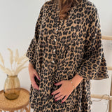 Kurzes locker fallendes Musselinkleid . 3/4 lange Arme im Trompetenschnitt. V- Ausschnitt mit Knopfleiste. Muster Leoprint in beige, braun, schwarz.
