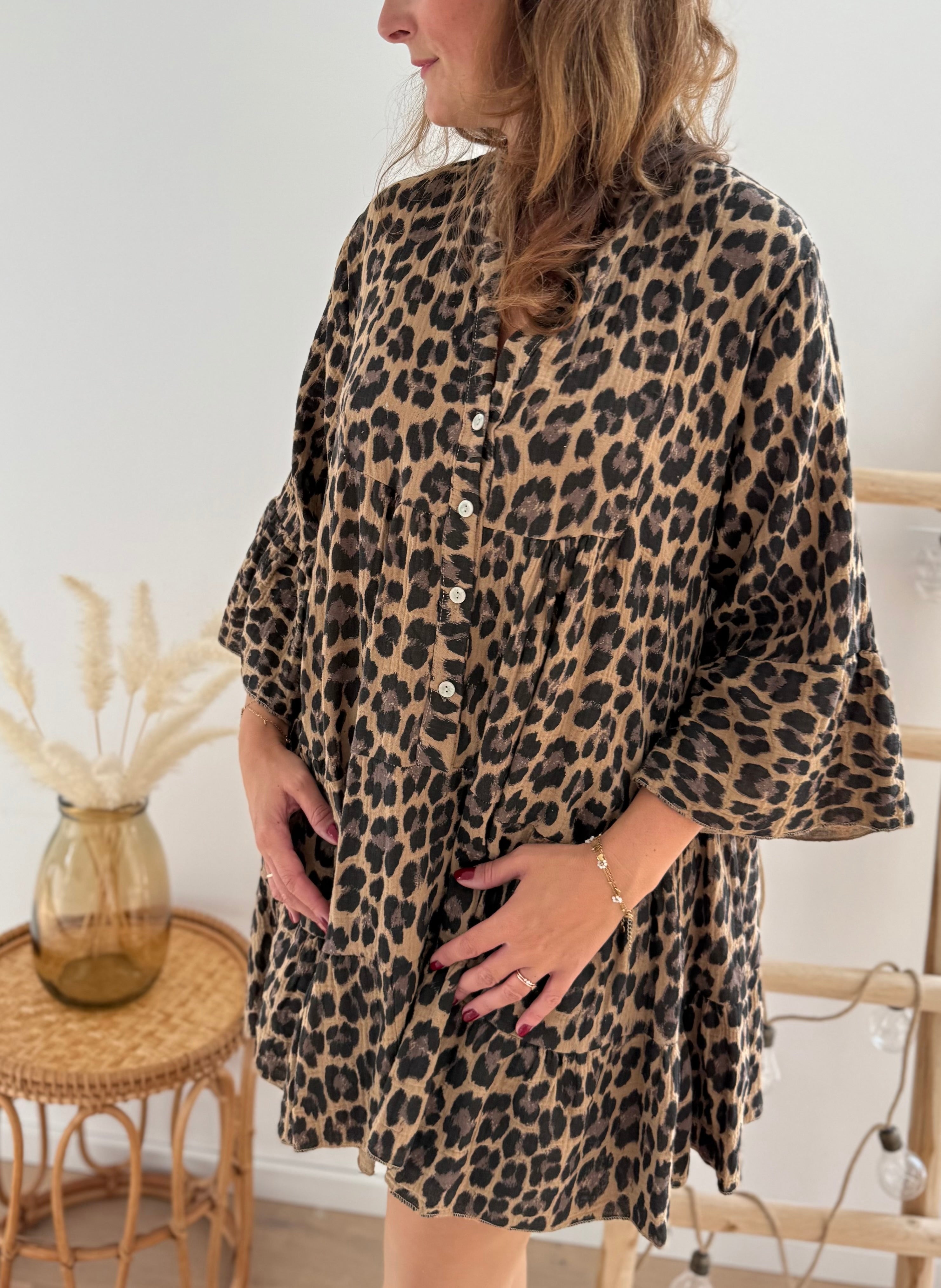 Kurzes locker fallendes Musselinkleid . 3/4 lange Arme im Trompetenschnitt. V- Ausschnitt mit Knopfleiste. Muster Leoprint in beige, braun, schwarz.
