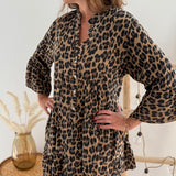 Kurzes locker fallendes Musselinkleid . 3/4 lange Arme im Trompetenschnitt. V- Ausschnitt mit Knopfleiste. Muster Leoprint in beige, braun, schwarz.