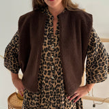 Kurzes locker fallendes Musselinkleid . 3/4 lange Arme im Trompetenschnitt. V- Ausschnitt mit Knopfleiste. Muster Leoprint in beige, braun, schwarz.