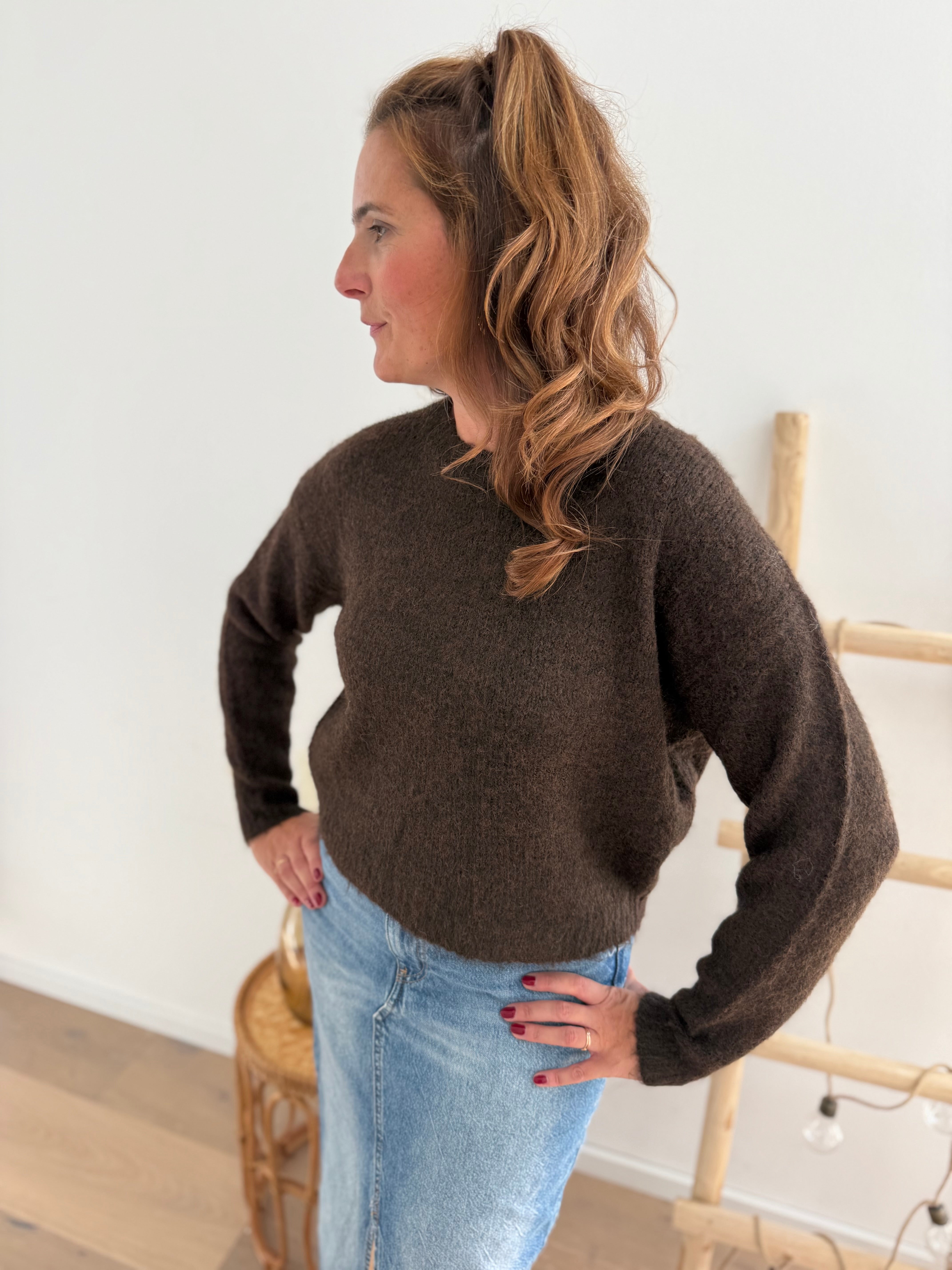Strickpullover in braun mit Rundhalsausschnitt. Hinten wird der Pulli von Schleifen im Leoprint Muster zusammengehalten.