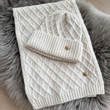 Beiges Schal & Mütze Set aus geflochtenem Strick mit kleiner goldenen Herzapplikation.