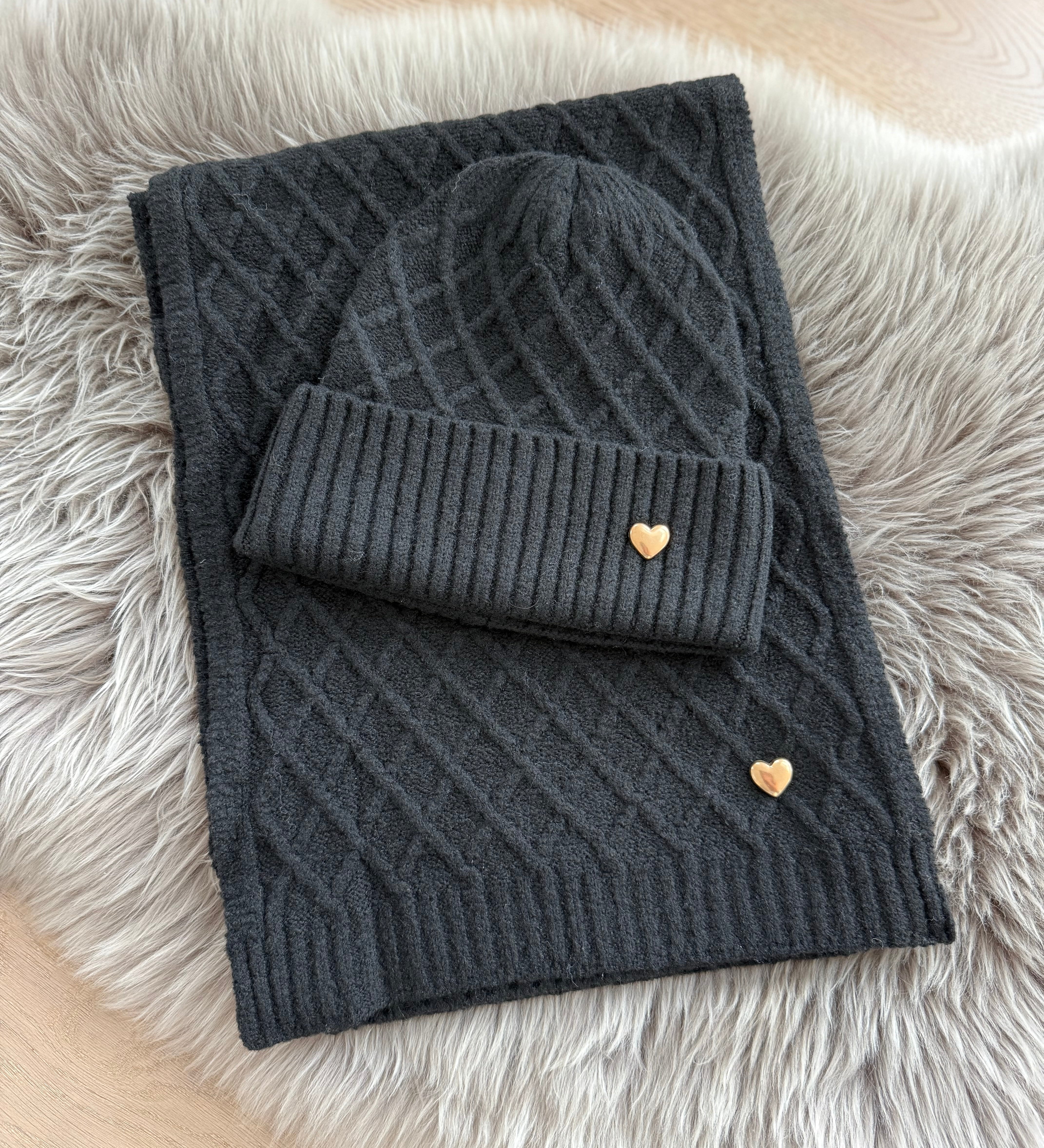 Schwarzes Schal & Mütze Set aus geflochtenem Strick mit kleiner goldenen Herzapplikation.