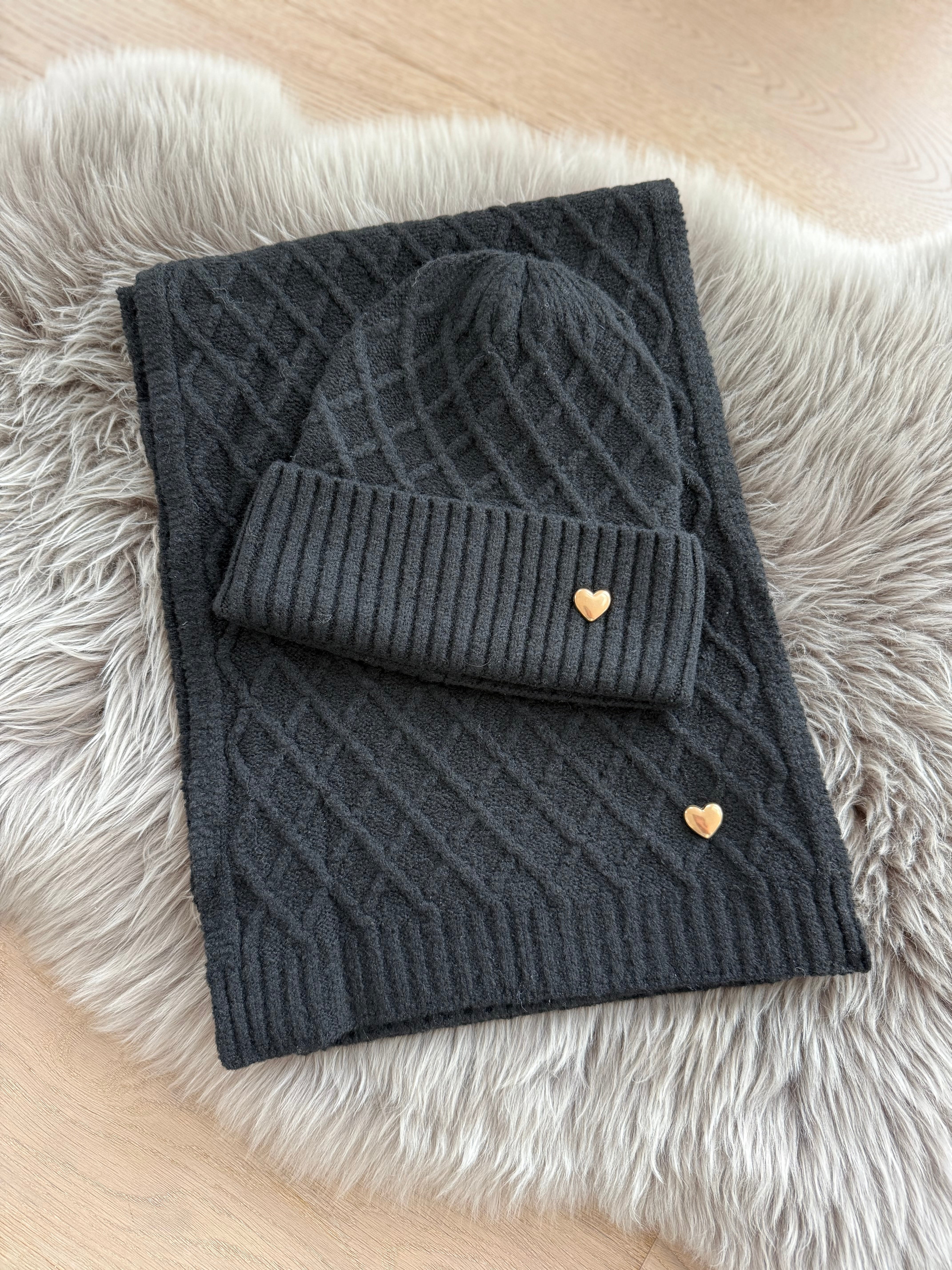 Schwarzes Schal & Mütze Set aus geflochtenem Strick mit kleiner goldenen Herzapplikation.