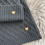Schwarzes Schal & Mütze Set aus geflochtenem Strick mit kleiner goldenen Herzapplikation.