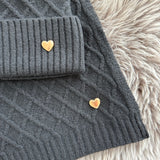 Schwarzes Schal & Mütze Set aus geflochtenem Strick mit kleiner goldenen Herzapplikation.