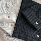 Set Schal & Mütze aus geflochtenem Strick mit kleiner goldenen Herzapplikation.