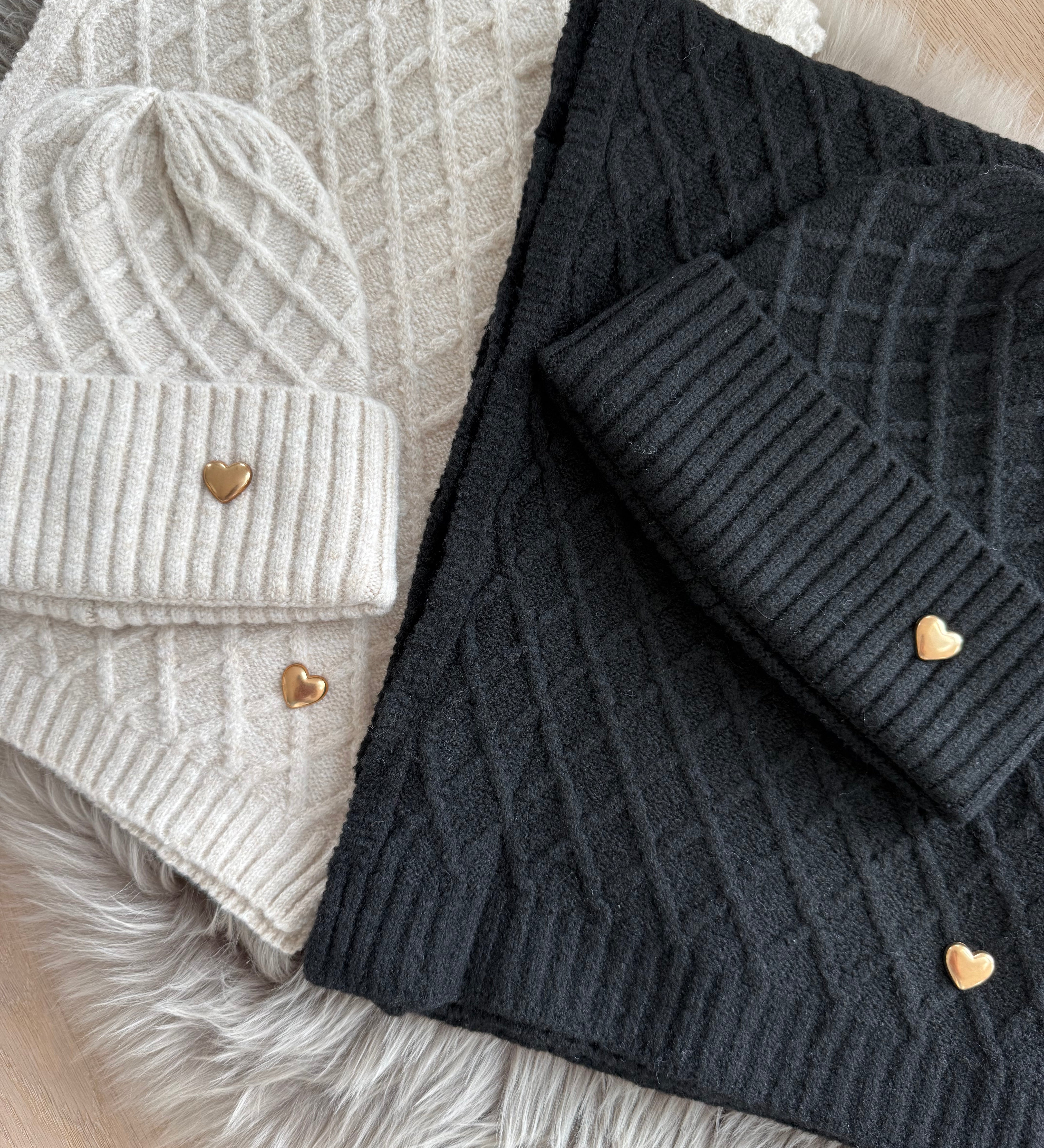 Set Schal & Mütze aus geflochtenem Strick mit kleiner goldenen Herzapplikation.