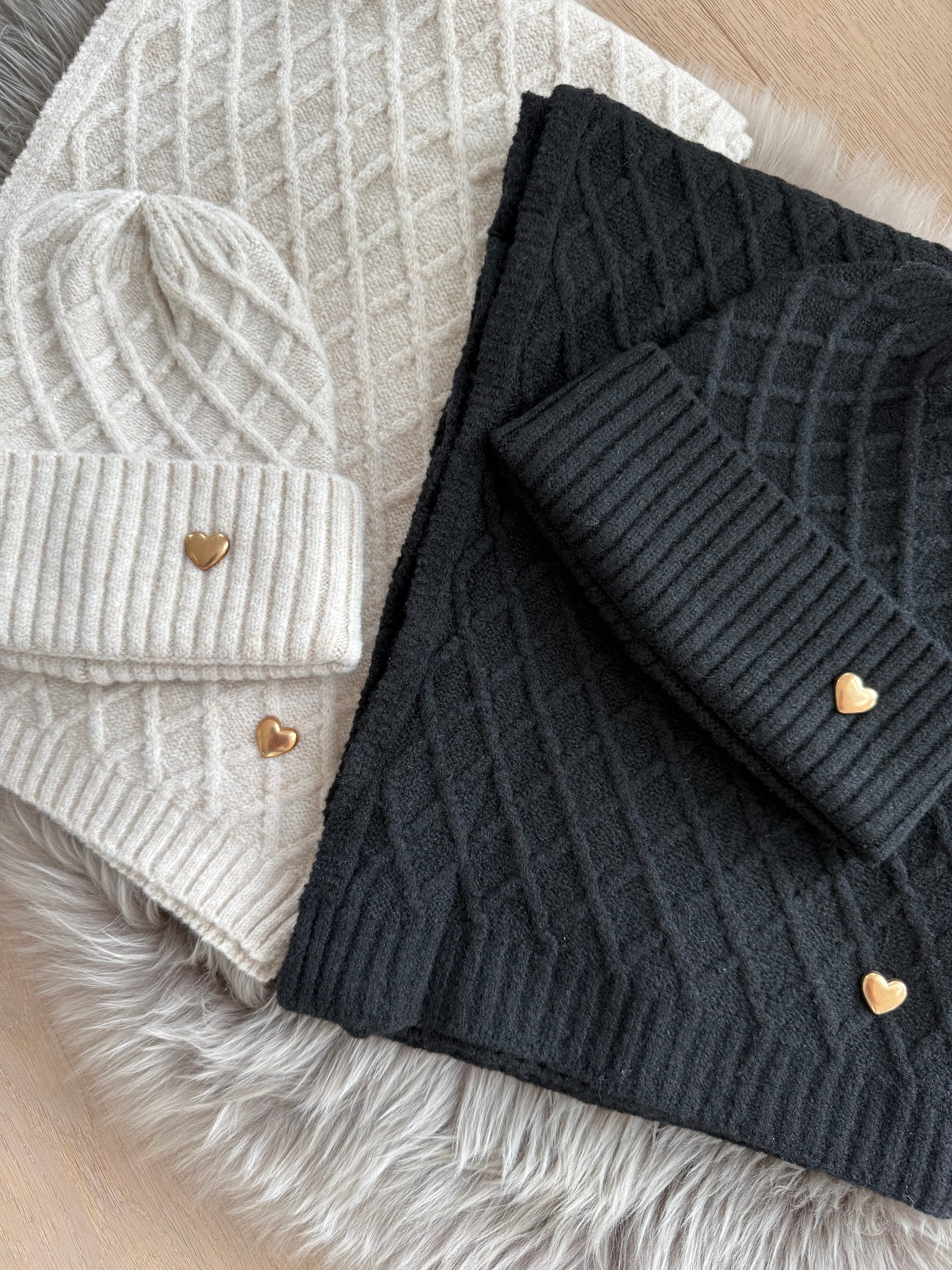 Set Schal & Mütze aus geflochtenem Strick mit kleiner goldenen Herzapplikation.
