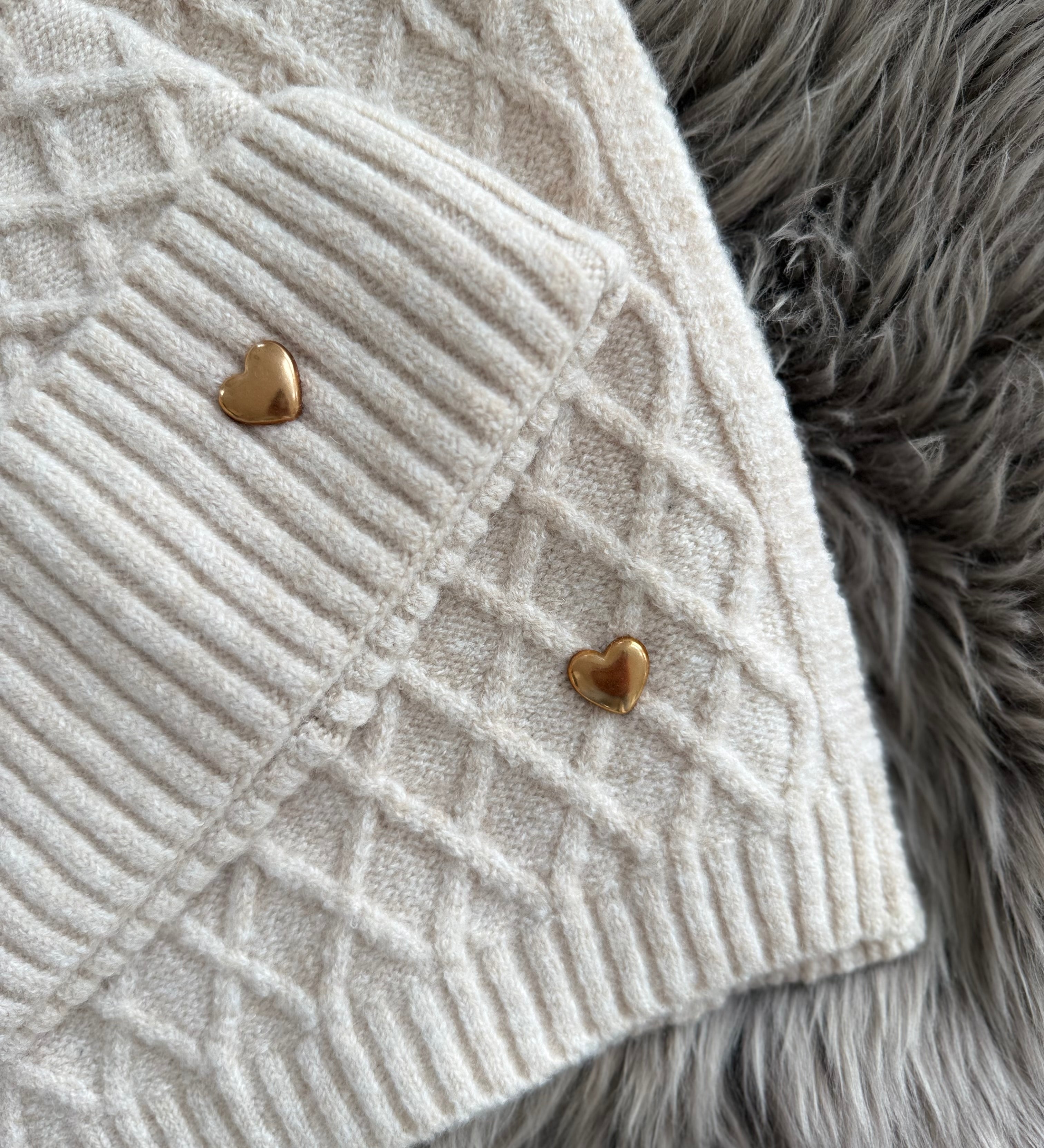 Beiges Schal & Mütze Set aus geflochtenem Strick mit kleiner goldenen Herzapplikation.