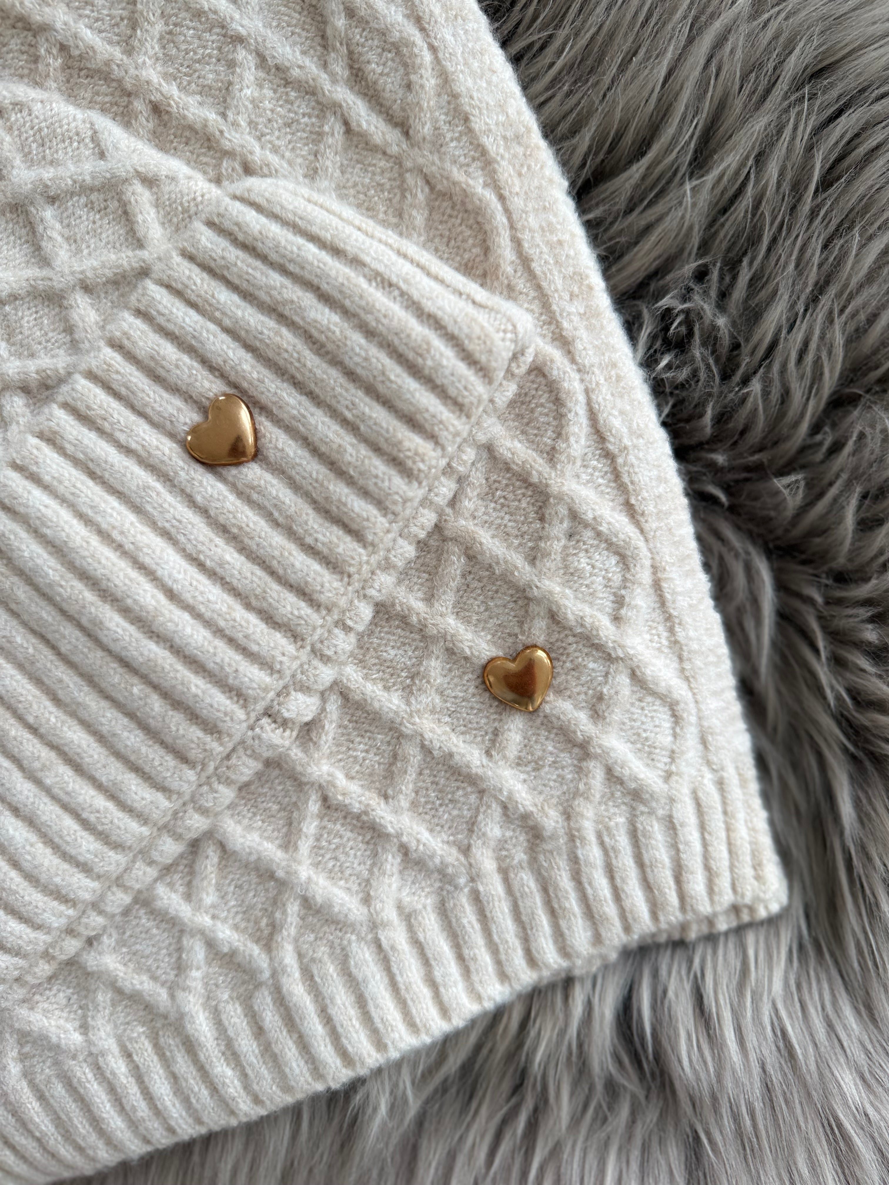 Beiges Schal & Mütze Set aus geflochtenem Strick mit kleiner goldenen Herzapplikation.