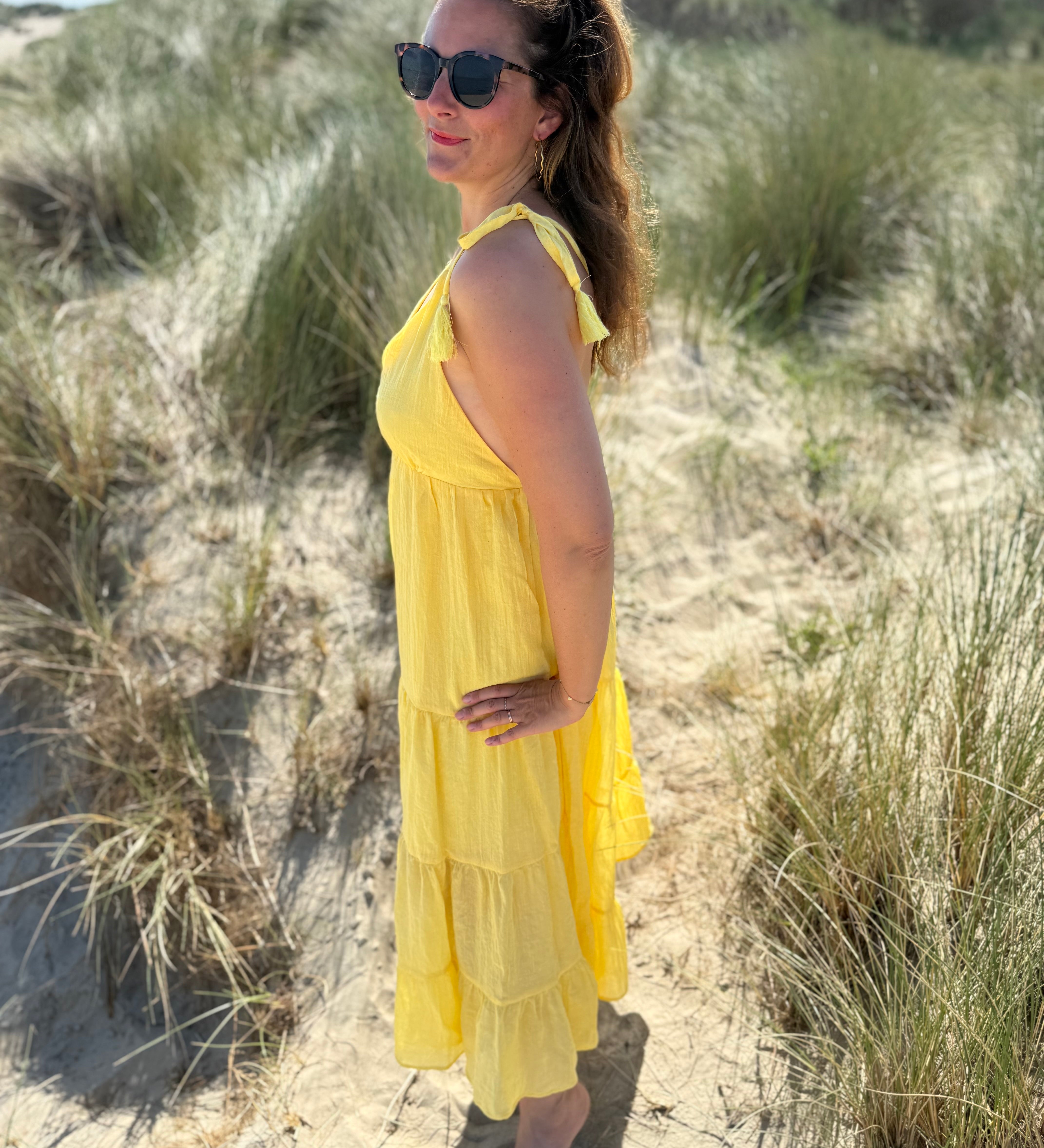 Langes leichtes Maxikleid in strahlendem gelb. Das Kleid hat einen V Ausschnitt und Spaghettiträger zum binden. 