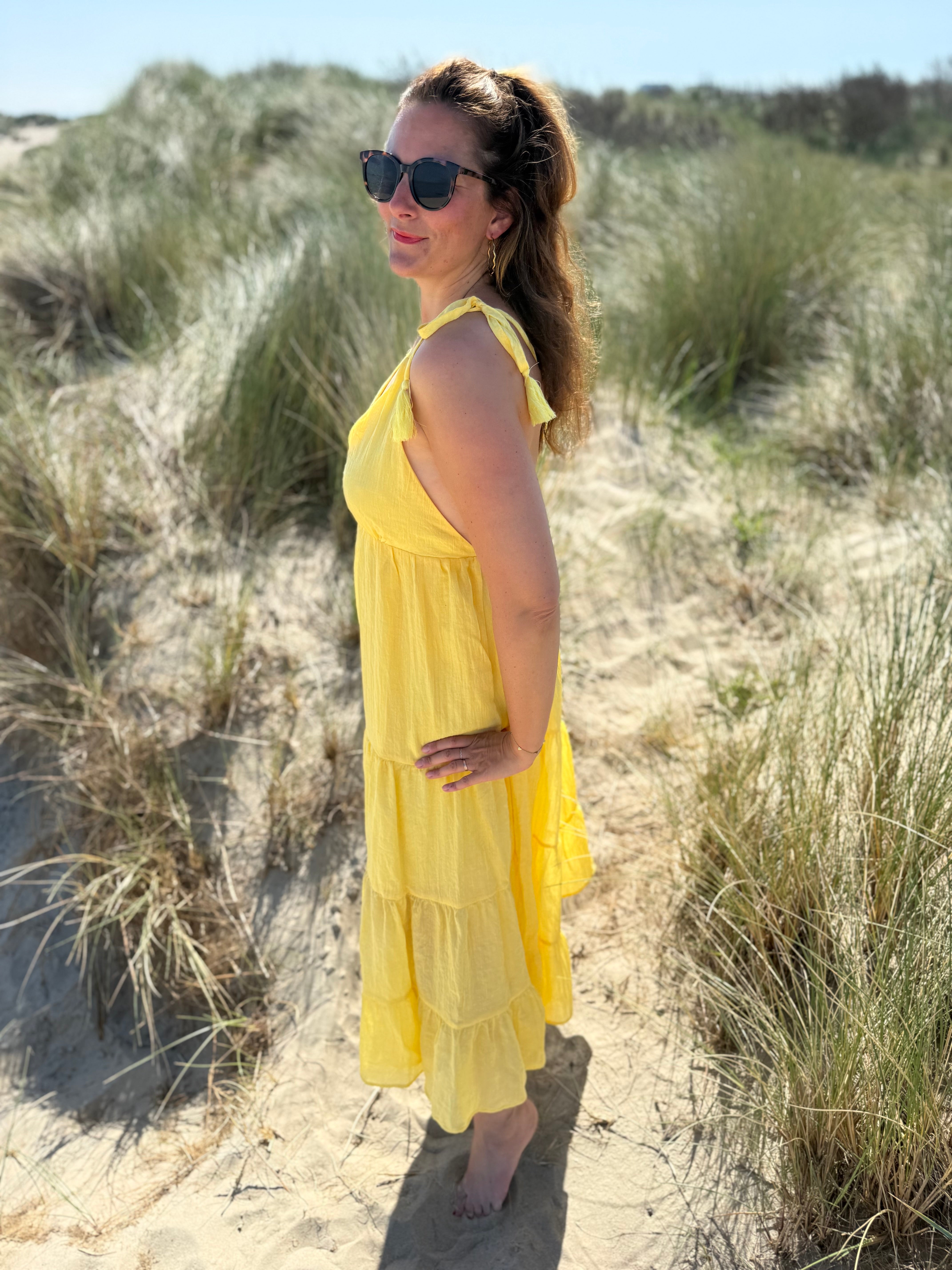Langes leichtes Maxikleid in strahlendem gelb. Das Kleid hat einen V Ausschnitt und Spaghettiträger zum binden. 