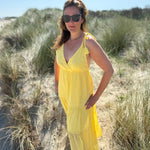 Langes leichtes Maxikleid in strahlendem gelb. Das Kleid hat einen V Ausschnitt und Spaghettiträger zum binden. 
