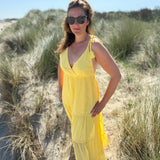 Langes leichtes Maxikleid in strahlendem gelb. Das Kleid hat einen V Ausschnitt und Spaghettiträger zum binden. 
