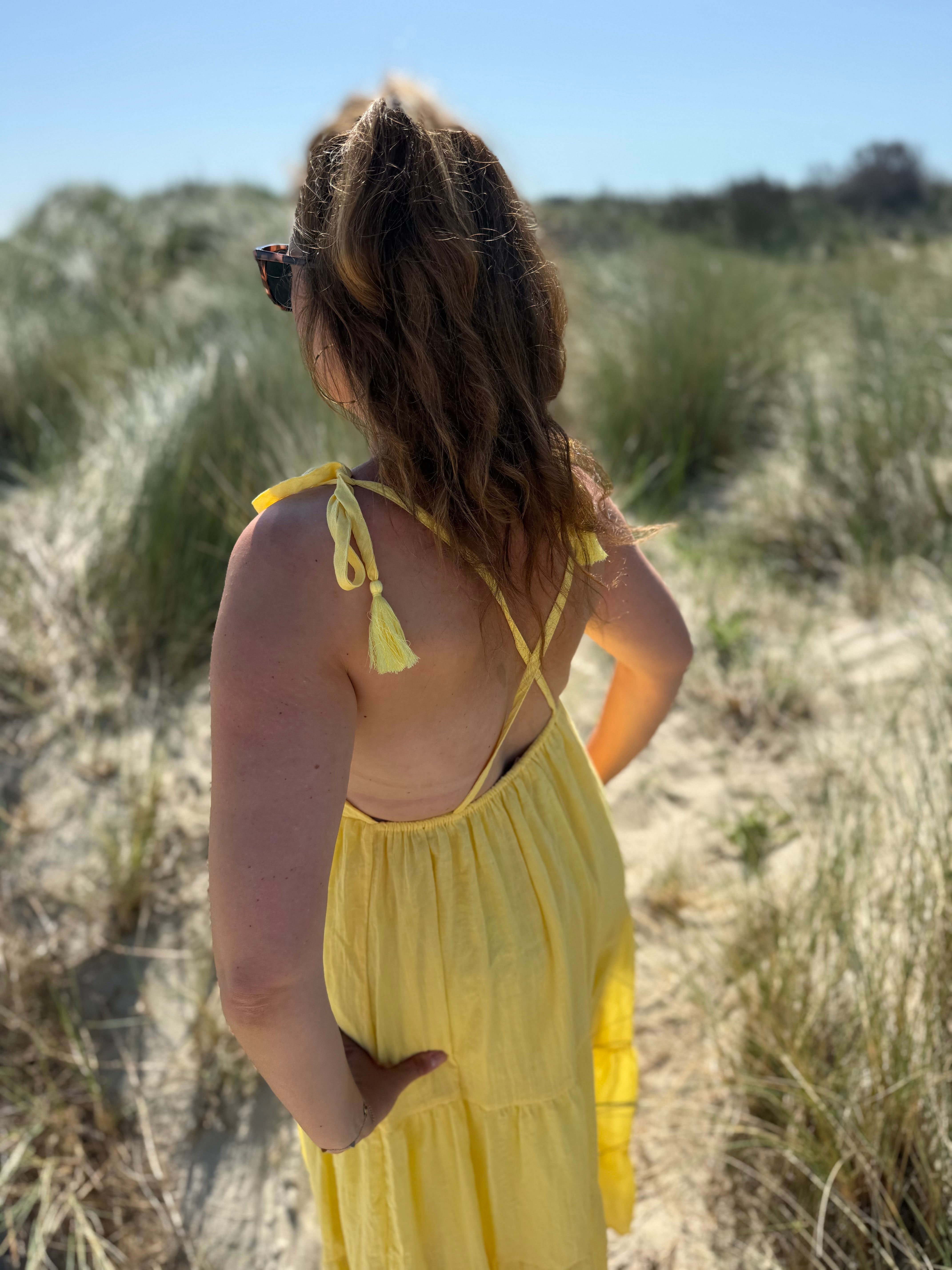 Langes leichtes Maxikleid in strahlendem gelb. Das Kleid hat einen V Ausschnitt und Spaghettiträger zum binden. 
