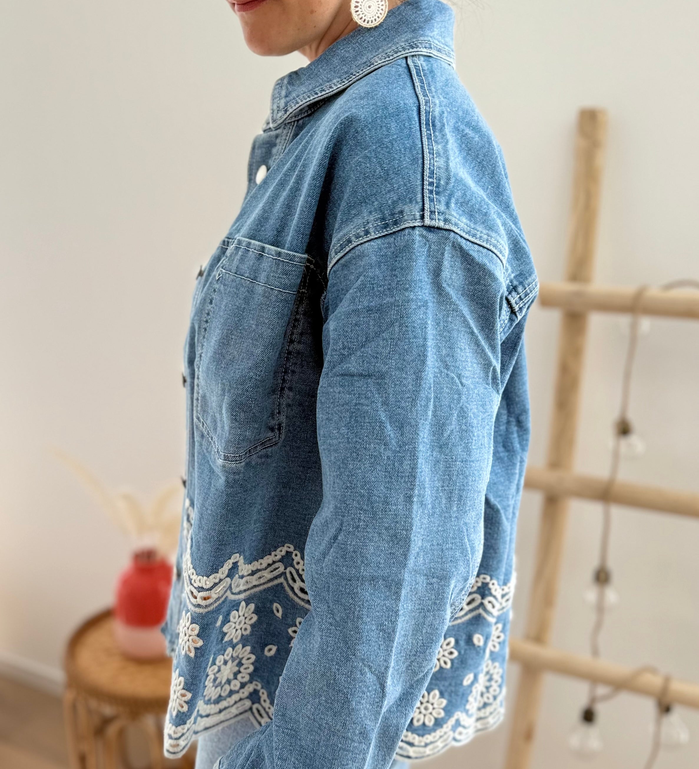 Verspielte blaue Jeansjacke im Oversize Look. Die wunderschöne weiße Lochstickerei mit Blumenmuster im unteren Bereich macht diese Jeansjacke zu einem ausgefallenen Lieblingsteil.