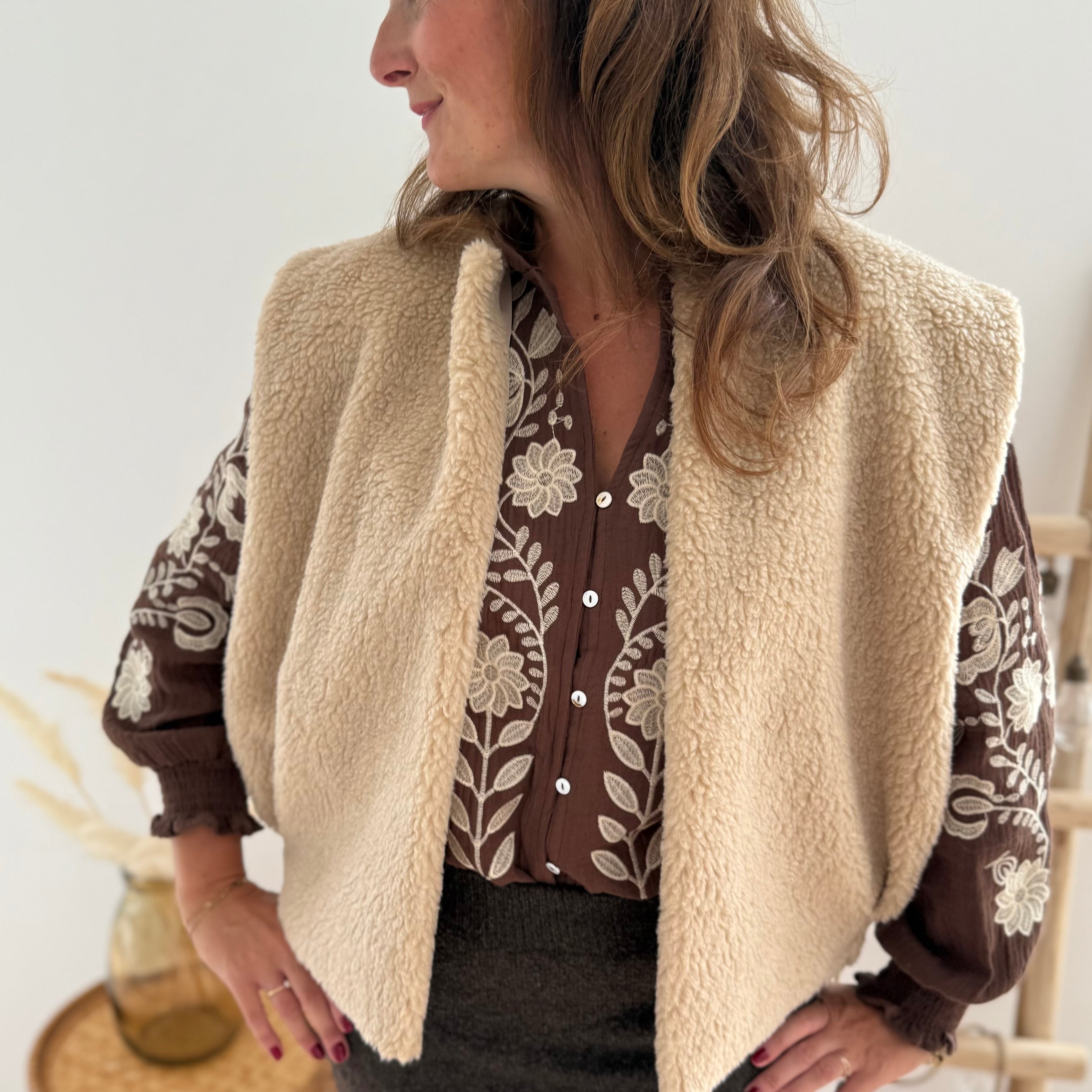 Kuschelige Teddyweste in beige. Die Weste hat einen lockeren kurzen Schnitt und wird ohne Knopfleiste offen getragen.