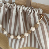 Gestreifte Tasche mit Bast am unteren Teil und einer abnehmbaren Perlenkette in den passenden Farben zu den Streifen. Farbe rosa beige.