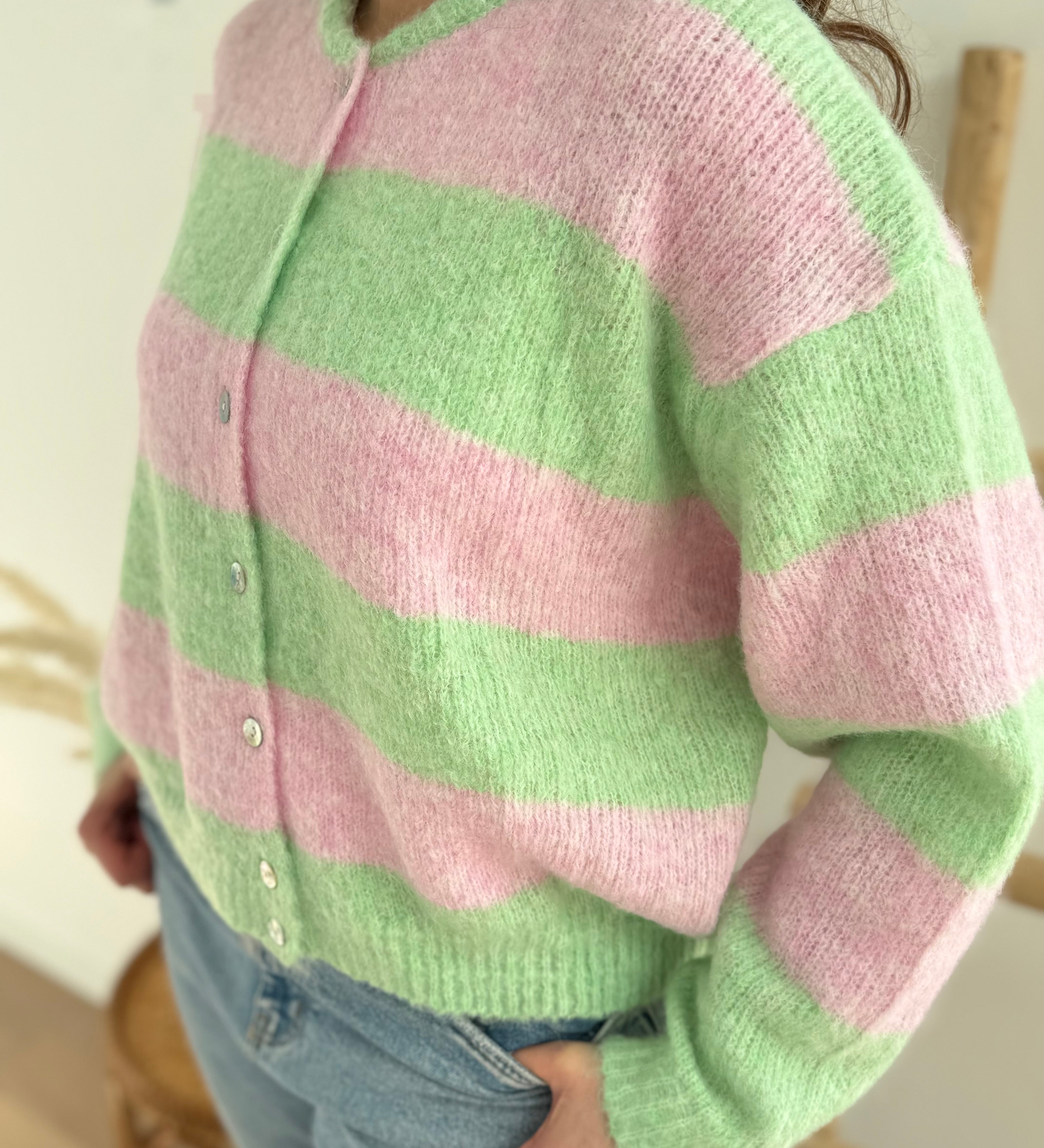 Strickjacke mit langen Ärmeln in rosa hellgrün gestreift. Die Strickjacke hat eine dezente Knopfleiste.