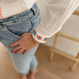 Leichte weiße Musselinbluse mit bunten Blumen Stickereien im Brustbereich und am Ärmelsaum