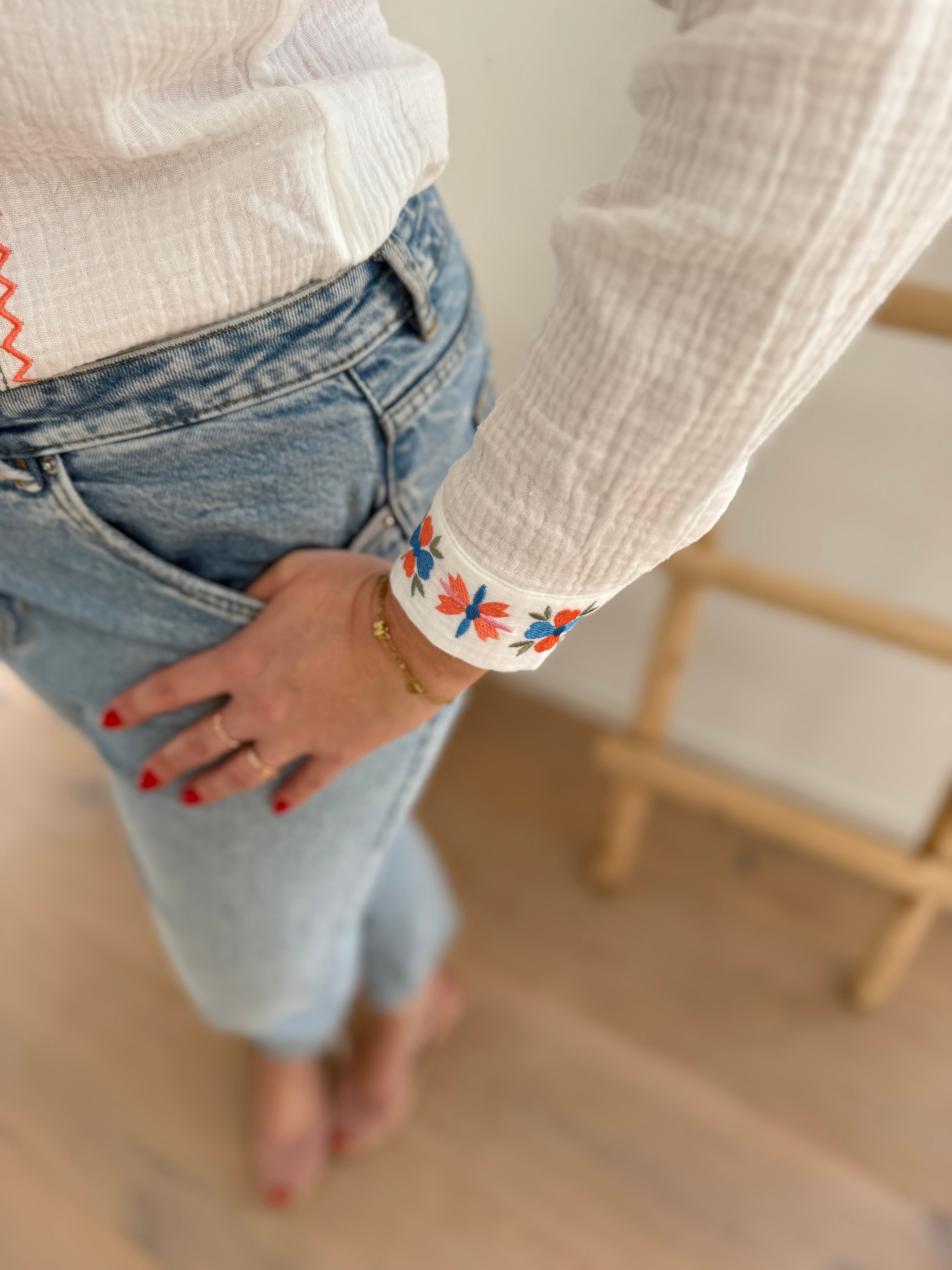 Leichte weiße Musselinbluse mit bunten Blumen Stickereien im Brustbereich und am Ärmelsaum