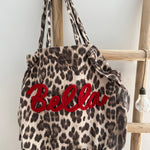 Große Shopper Bag aus strapazierfähigem Denim Stoff. Tasche ist in Leomuster mit rotem "Bella" Schriftzug aufgedruckt.