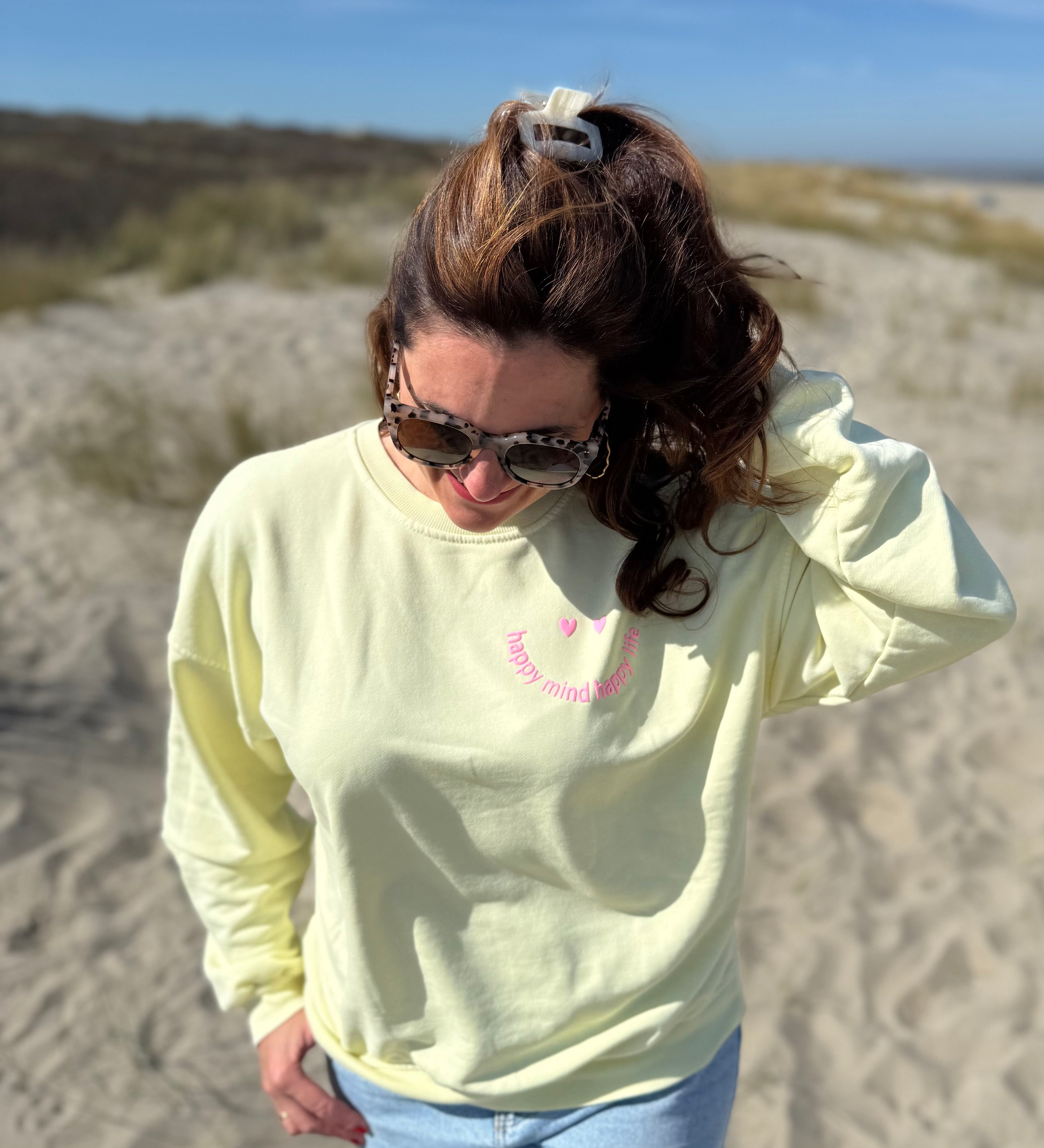 Locker geschnittenes Sweatshirt in butter yellos mit einem rosanen Smiley auf der Brust.