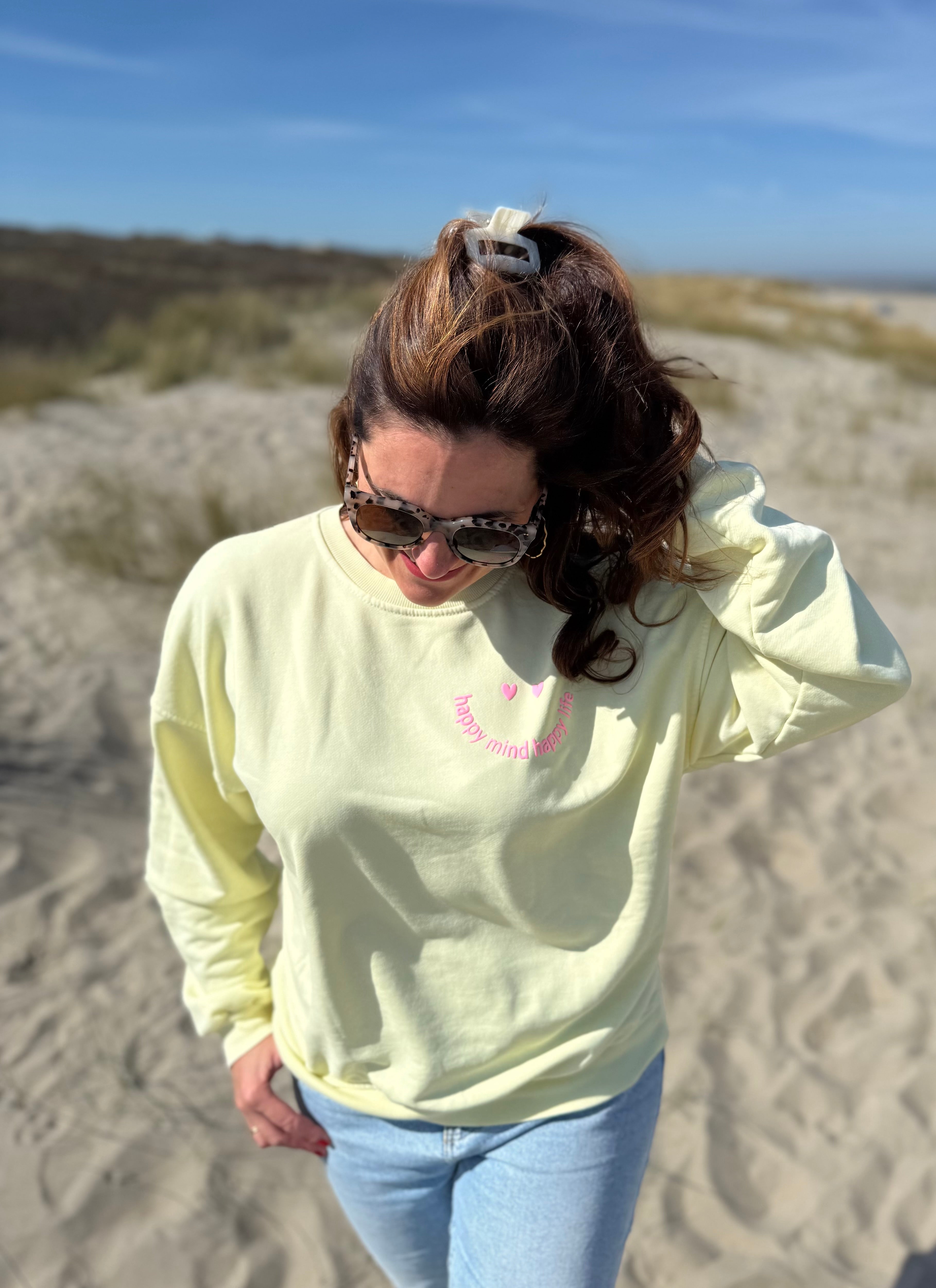 Locker geschnittenes Sweatshirt in butter yellos mit einem rosanen Smiley auf der Brust.
