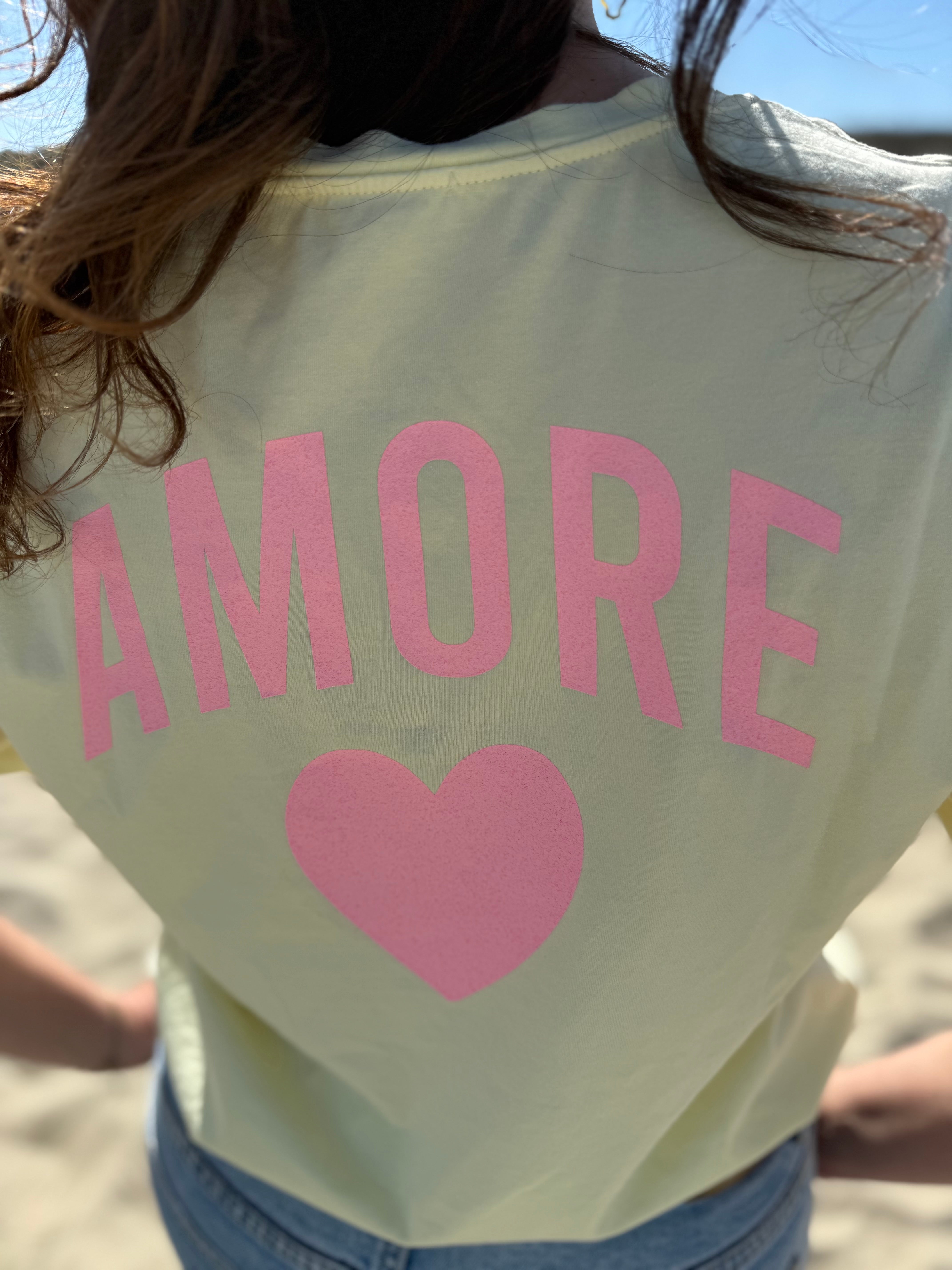 Oversize T-Shirt zum Verlieben. Kleines süßes Herz auf der Brust und ein großer Statement Print auf dem Rücken in rosa mit Amore. Das T-Shirt ist butter yellow.