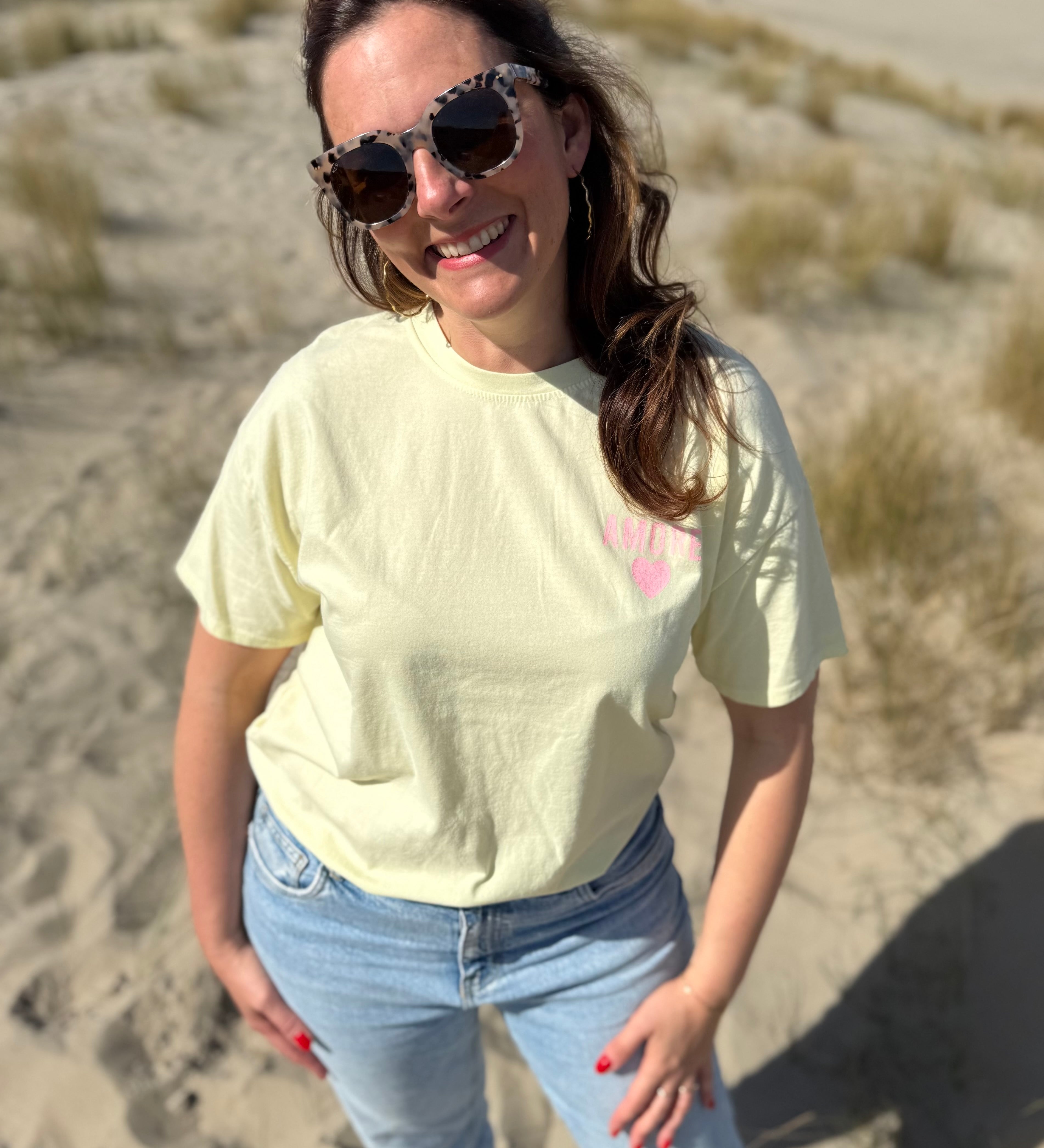 Oversize T-Shirt zum Verlieben. Kleines süßes Herz auf der Brust und ein großer Statement Print auf dem Rücken in rosa mit Amore. Das T-Shirt ist butter yellow.