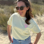 Oversize T-Shirt zum Verlieben. Kleines süßes Herz auf der Brust und ein großer Statement Print auf dem Rücken in rosa mit Amore. Das T-Shirt ist butter yellow.