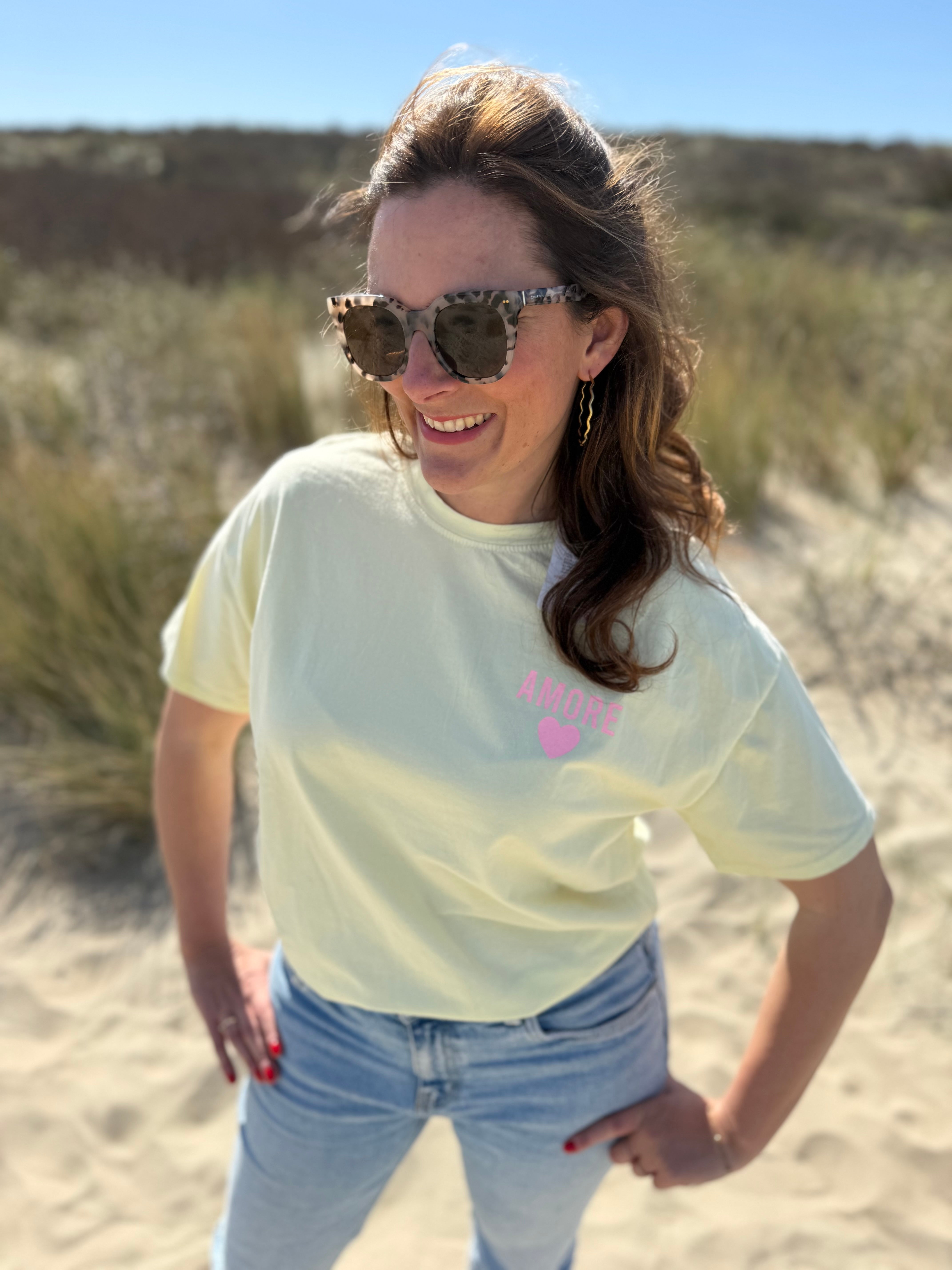 Oversize T-Shirt zum Verlieben. Kleines süßes Herz auf der Brust und ein großer Statement Print auf dem Rücken in rosa mit Amore. Das T-Shirt ist butter yellow.