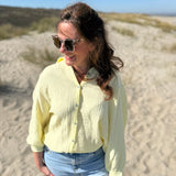 Musselinbluse im lockeren Oversize Look mit langen Ärmeln. Eyecatcher ist ein bunter GOOD VIBES Aufdruck am Rücken. Die Bluse ist in butter yellow