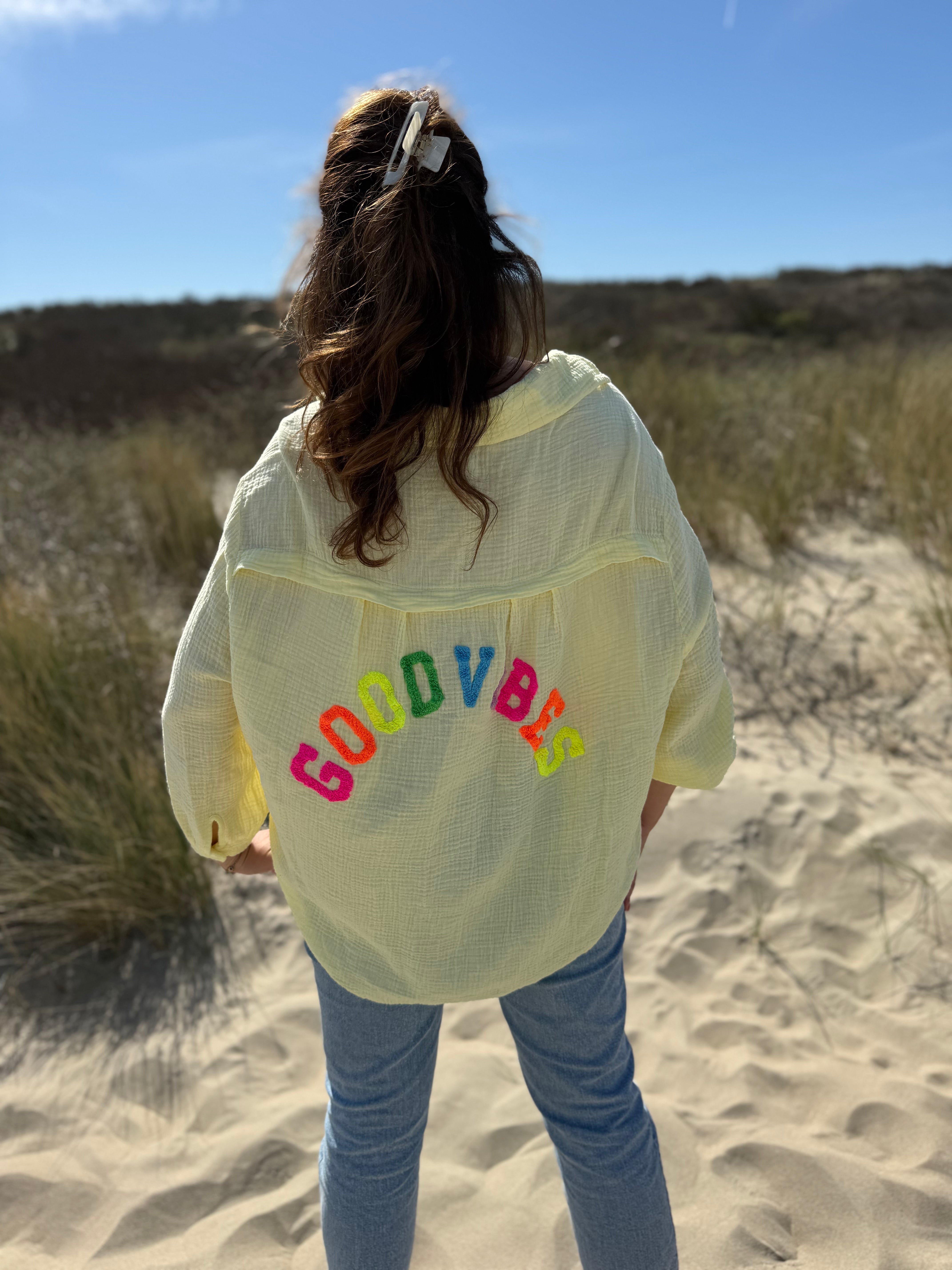 Musselinbluse im lockeren Oversize Look mit langen Ärmeln. Eyecatcher ist ein bunter GOOD VIBES Aufdruck am Rücken. Die Bluse ist in butter yellow