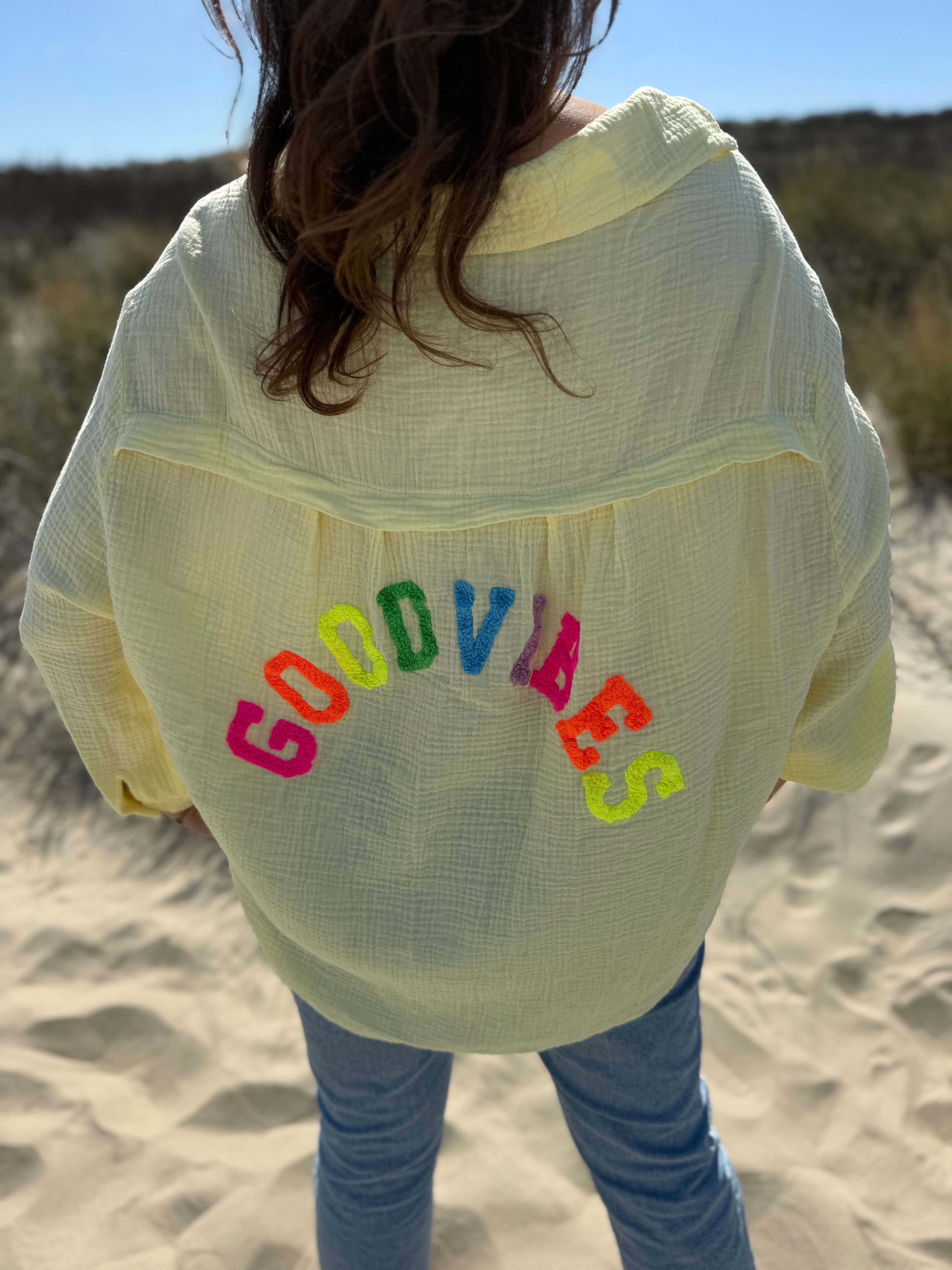 Musselinbluse im lockeren Oversize Look mit langen Ärmeln. Eyecatcher ist ein bunter GOOD VIBES Aufdruck am Rücken. Die Bluse ist in butter yellow
