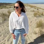 Musselinbluse im lockeren Oversize Look mit langen Ärmeln. Eyecatcher ist ein bunter GOOD VIBES Aufdruck am Rücken. Die Bluse ist weiß.