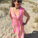 Musselinkleid in Maxilänge mit V Ausschnitt und kurzen Flügelärmeln. Das Kleid ist rosa mit pink, gelb und orangenen Ethno Muster.