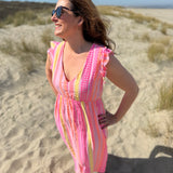 Musselinkleid in Maxilänge mit V Ausschnitt und kurzen Flügelärmeln. Das Kleid ist rosa mit pink, gelb und orangenen Ethno Muster.