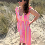 Musselinkleid in Maxilänge mit V Ausschnitt und kurzen Flügelärmeln. Das Kleid ist rosa mit pink, gelb und orangenen Ethno Muster.