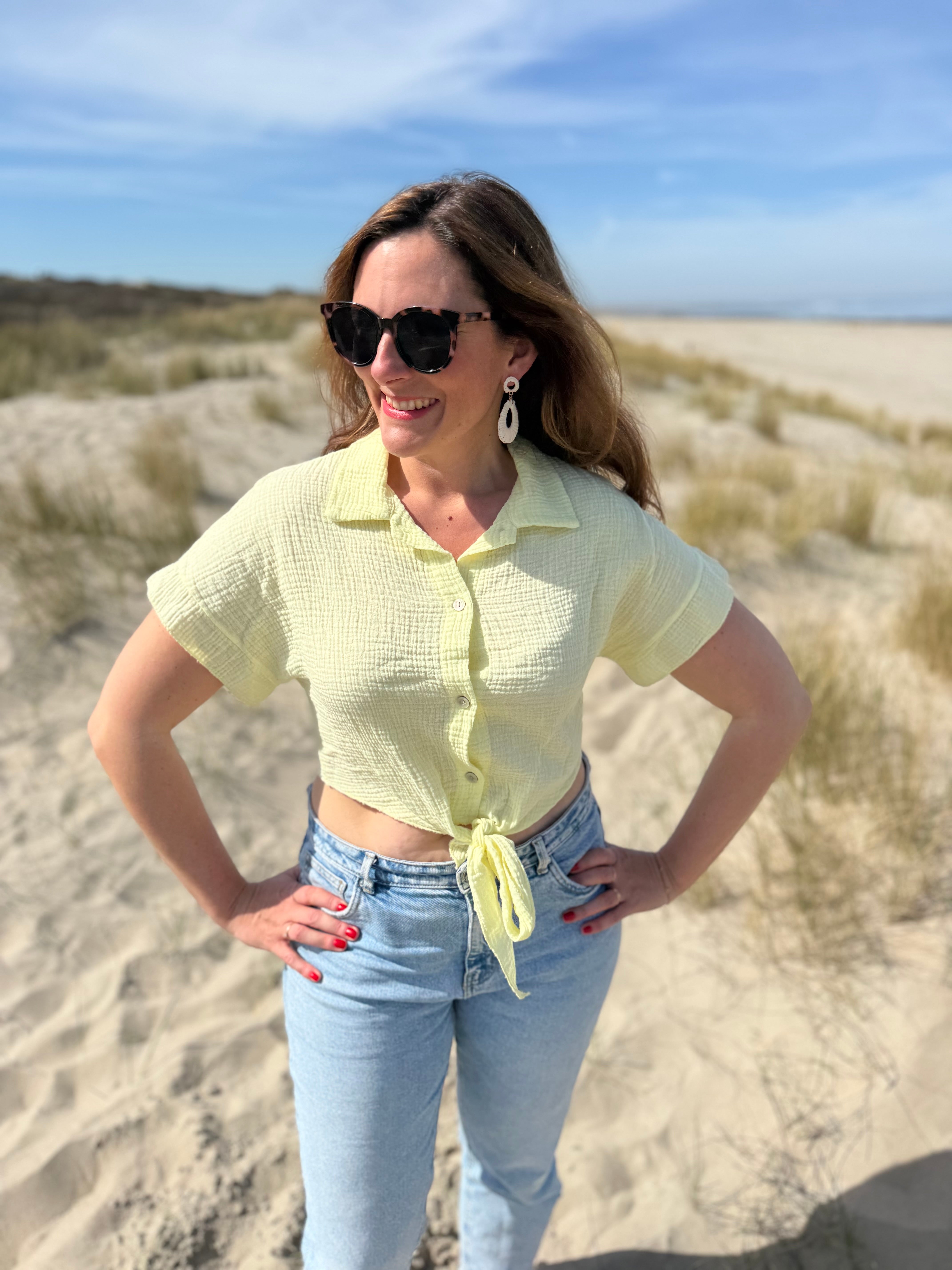 Musselinbluse in cropped Schnitt zum binden. Die Bluse hat kurze Flügelärmel und ist butter yellow.