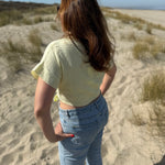Musselinbluse in cropped Schnitt zum binden. Die Bluse hat kurze Flügelärmel und ist butter yellow.