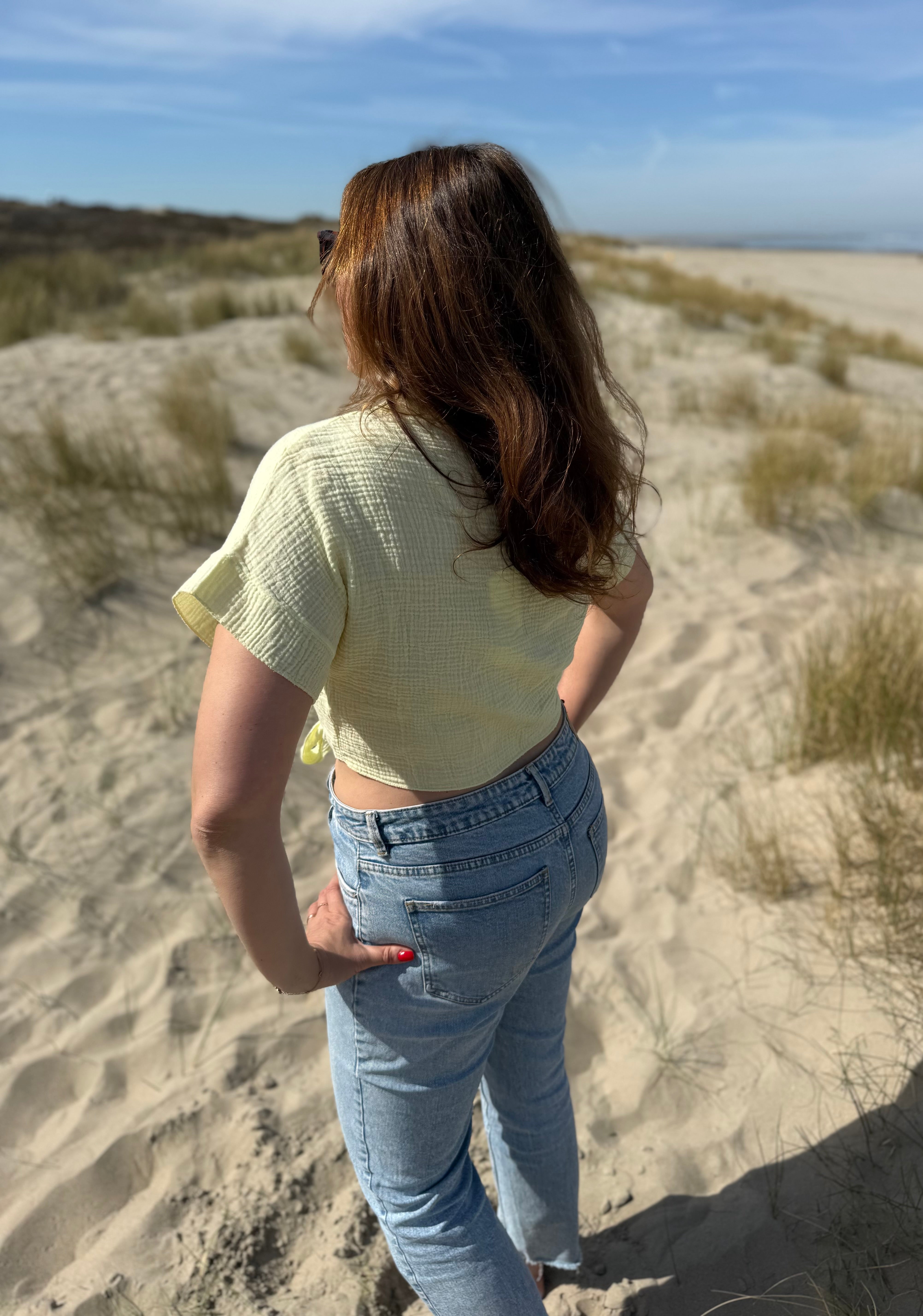 Musselinbluse in cropped Schnitt zum binden. Die Bluse hat kurze Flügelärmel und ist butter yellow.